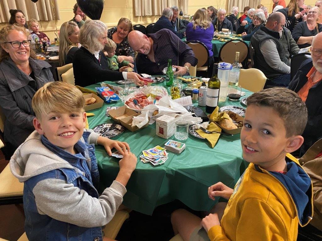 Youngsters Dylan and James Rees had time for a few games of cards while the 150th anniversary speeches were going on at the Poowong Hall last Saturday night. They then helped out by dealing out pieces of birthday cake.