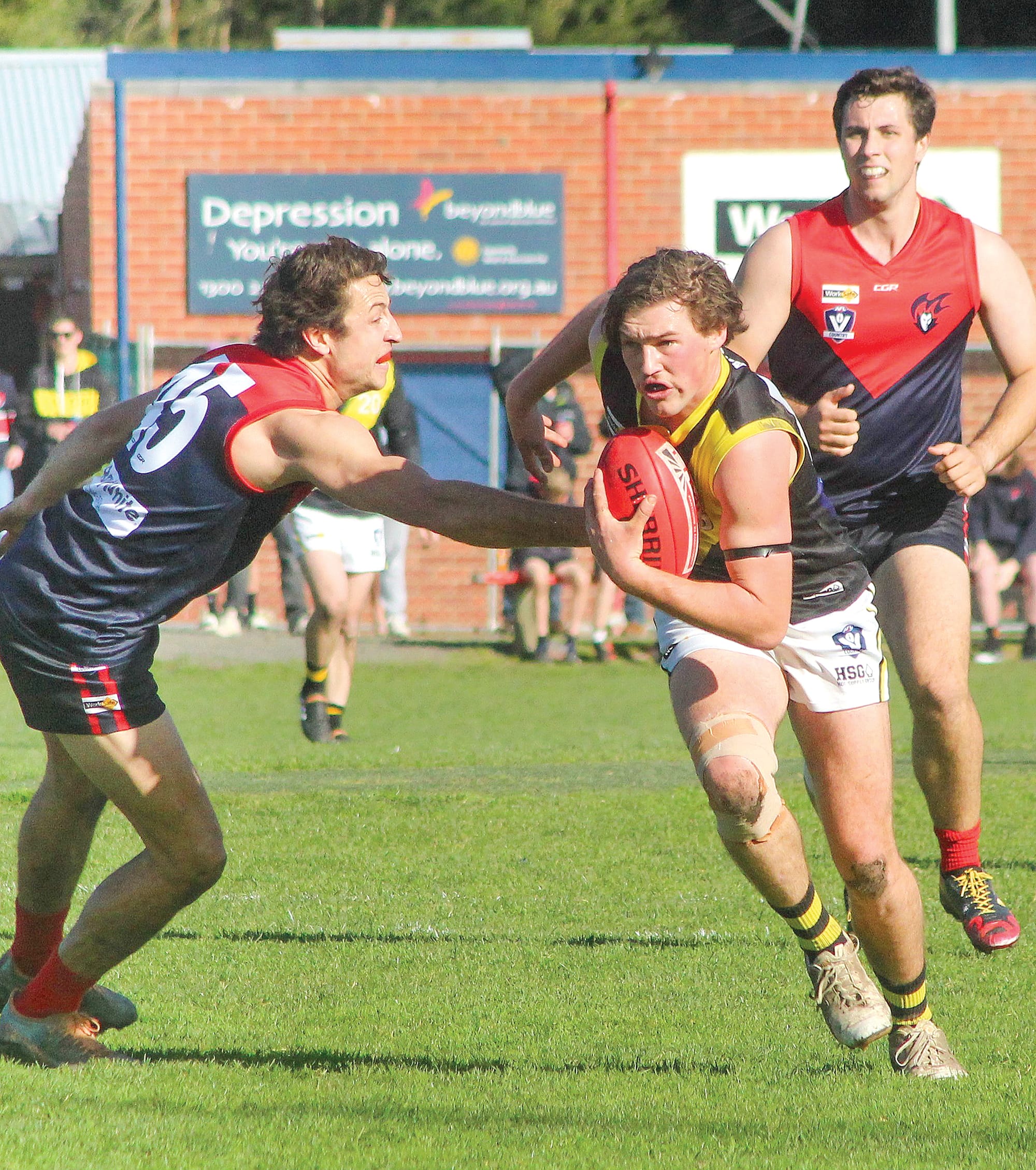Mirboo North’s Beau Melbourne looks to break the tackle of Sam Wilson as he gets away from the stoppage on Saturday.