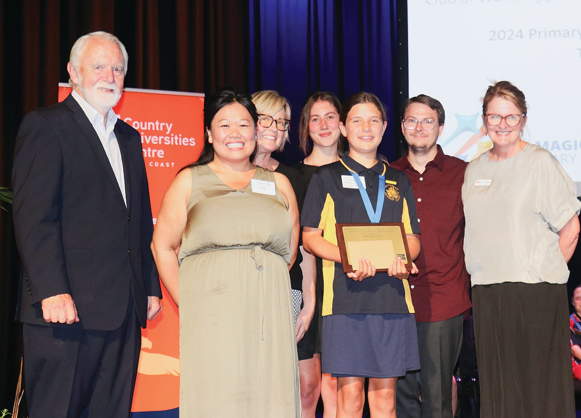 Don Paproth, Nicki Chung, Amanda Mc Mahon, Sophie Hogan, Alex Charlton, and Sarah Bourke congratulate first place winner of the 2024 Primary Schools Public Speaking Competition to Newhaven Primary School student, Tasmin Watson. Z26_4324 

