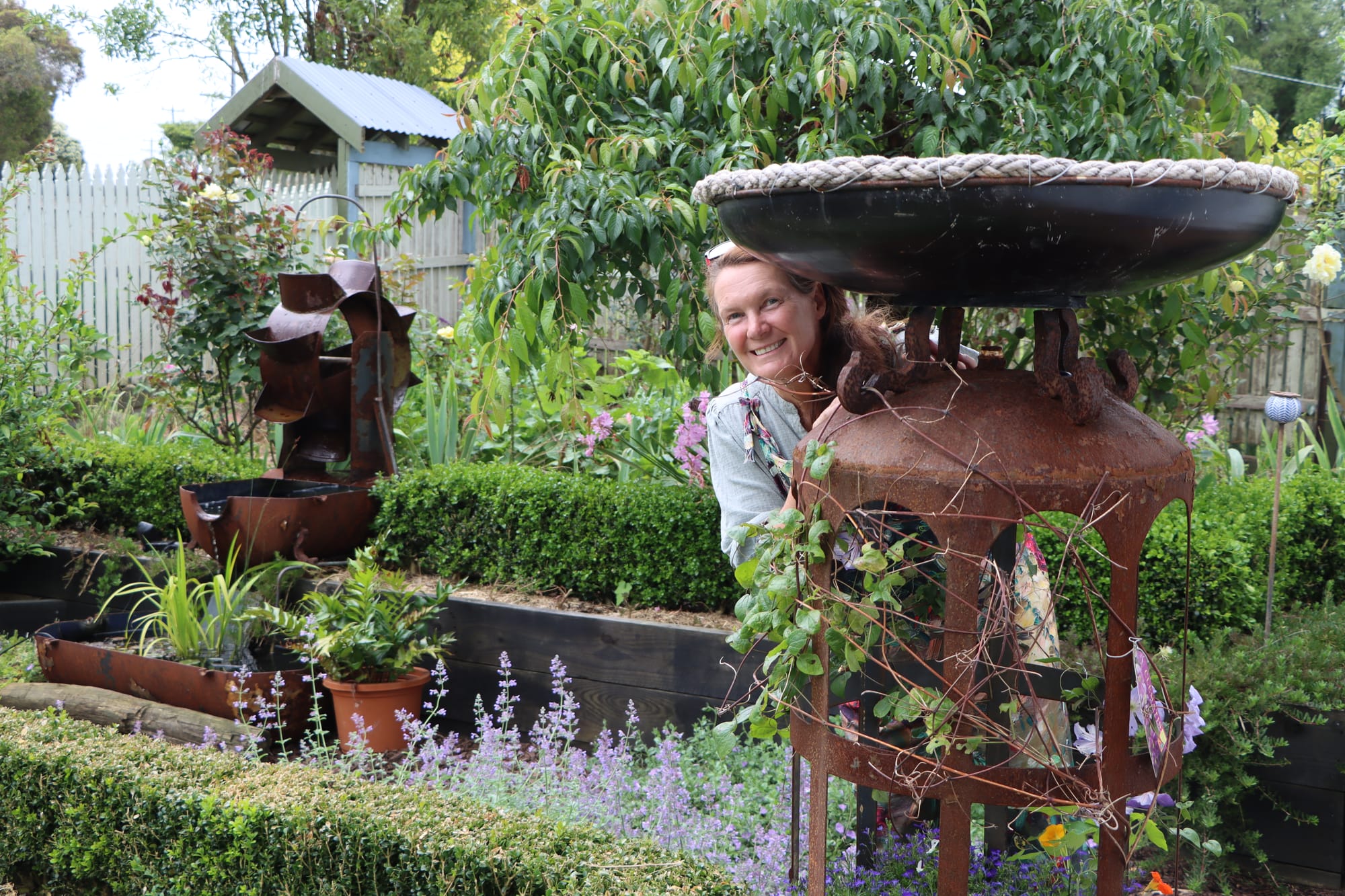 Fiona Bilbrough in her garden with a piece made from an old hot water service