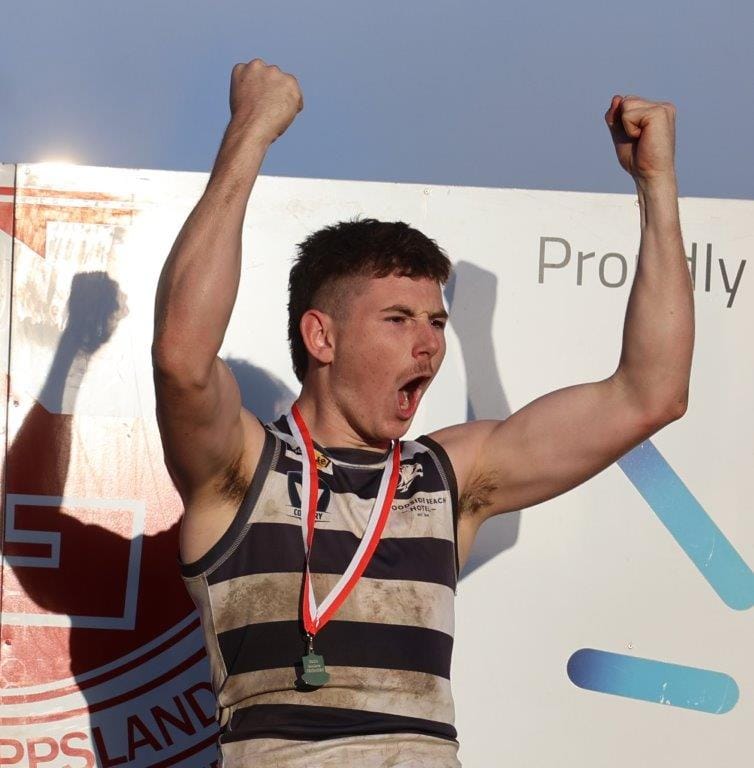 Woodsisde Wildcats’ player Jai Williams celebrates the win on the presentation dais after the teams’ grand final win.
