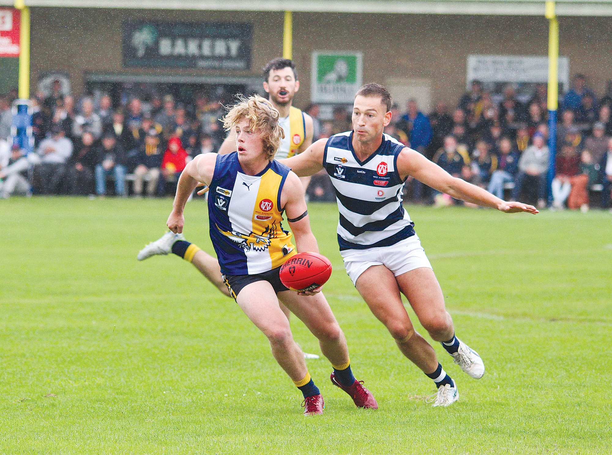 Sea Eagles young gun William Turner looks to give off the handpass in the wet at the Inverloch Recreation Reserve. 

