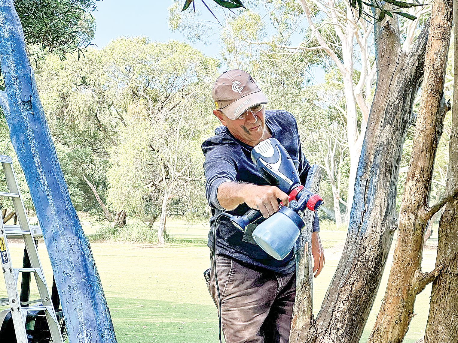 Michael Rowe was in charge of the paint sprayer for the painting of the tree at LGC as part of the Blue Tree Project bringing a spotlight to men’s mental health. ob05_0424