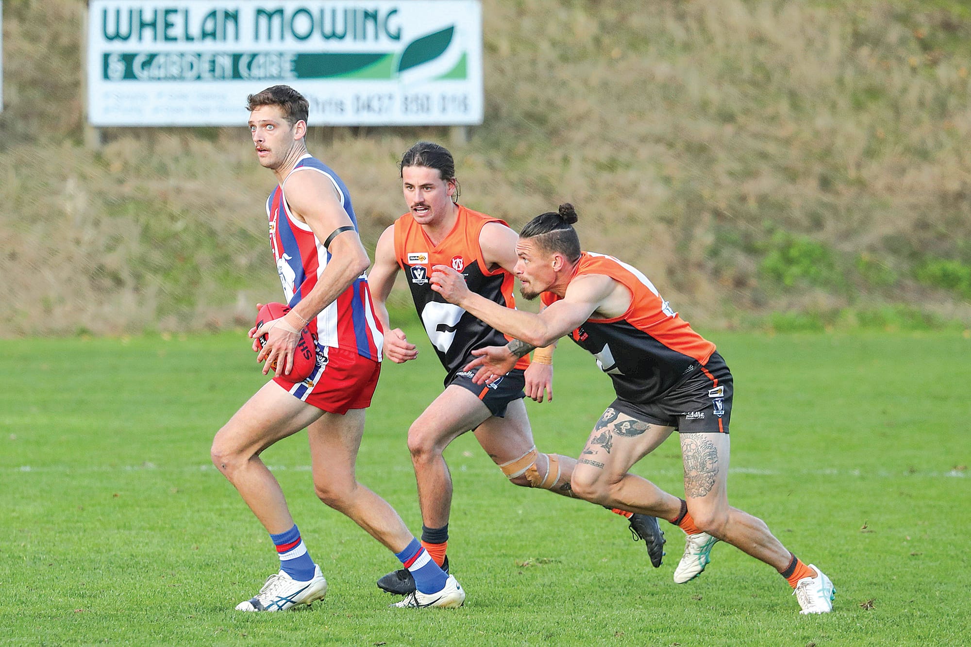 Jesse Patullo prepares to kick the ball up field as his Giants opponents close in. 