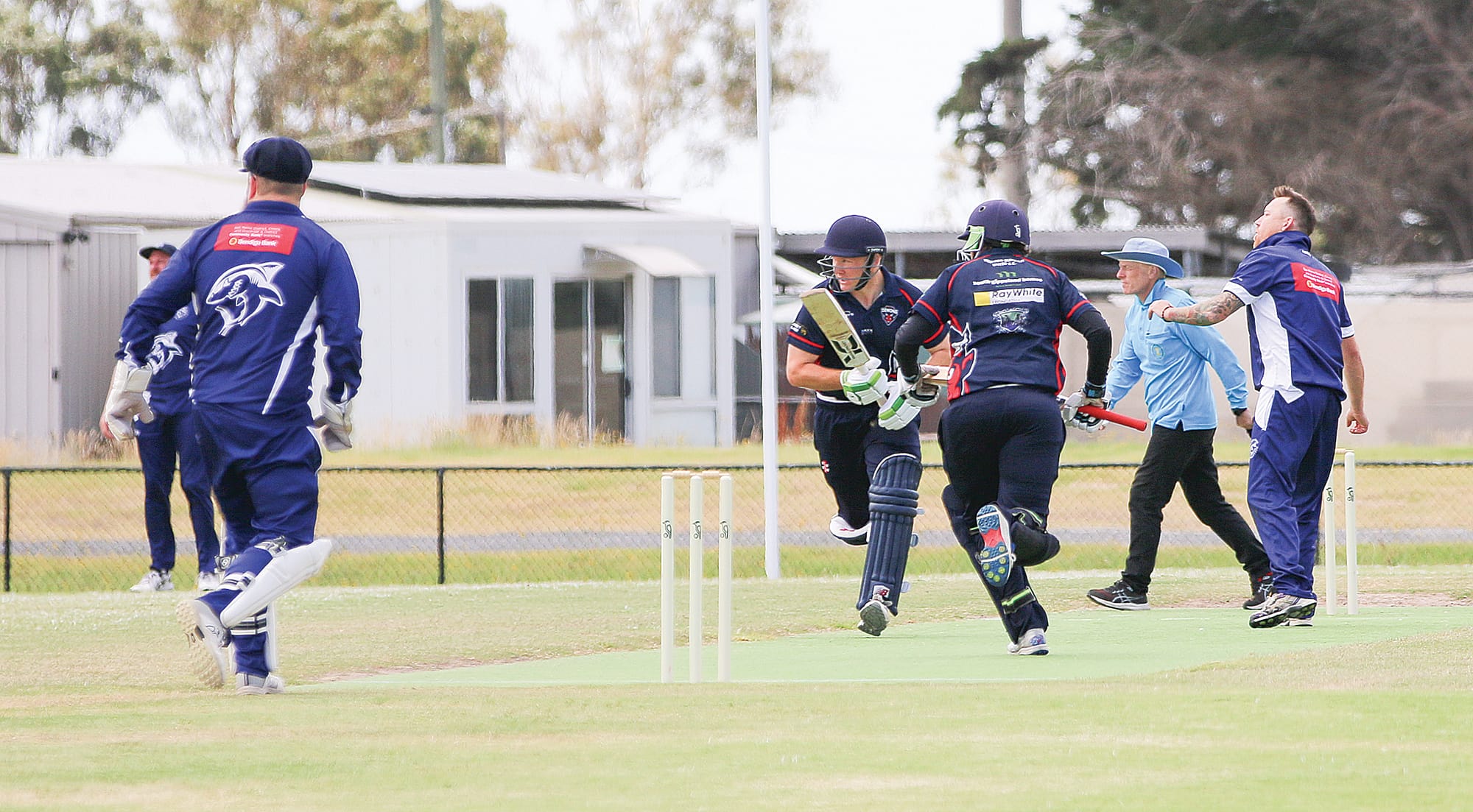 Kilcunda-Bass bowler Brad Wright watches the fielding effort while MDU batsmen Joel Sinclair and Mitch McGrath add a few more runs to their tally.
