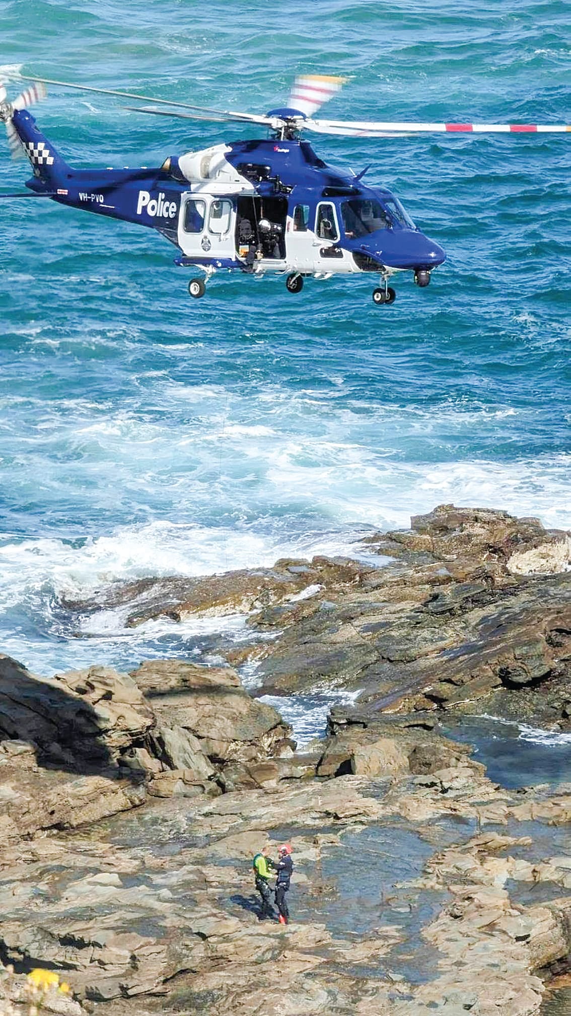 A woman has died and a man is missing after being washed off the rocks this morning at Punch Bowl. 
The location is notorious with a rock-fisherman winched to safety on November 13, 2023 (pictured), after he was swept off the rocks while retrieving a fish. He was in the water for several hours before the emergency call went out, and was wearing an approved personal flotation device.
It's unknown at this stage what the three people were doing on the rocks this morning or whether rock-fishing was involved.