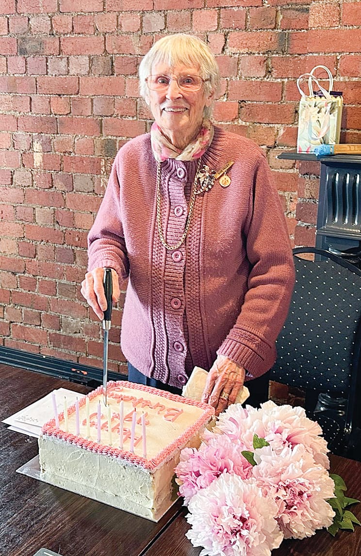 Avis Tilley cuts her surprise birthday cake at her 99th birthday celebrations. ob08_3924