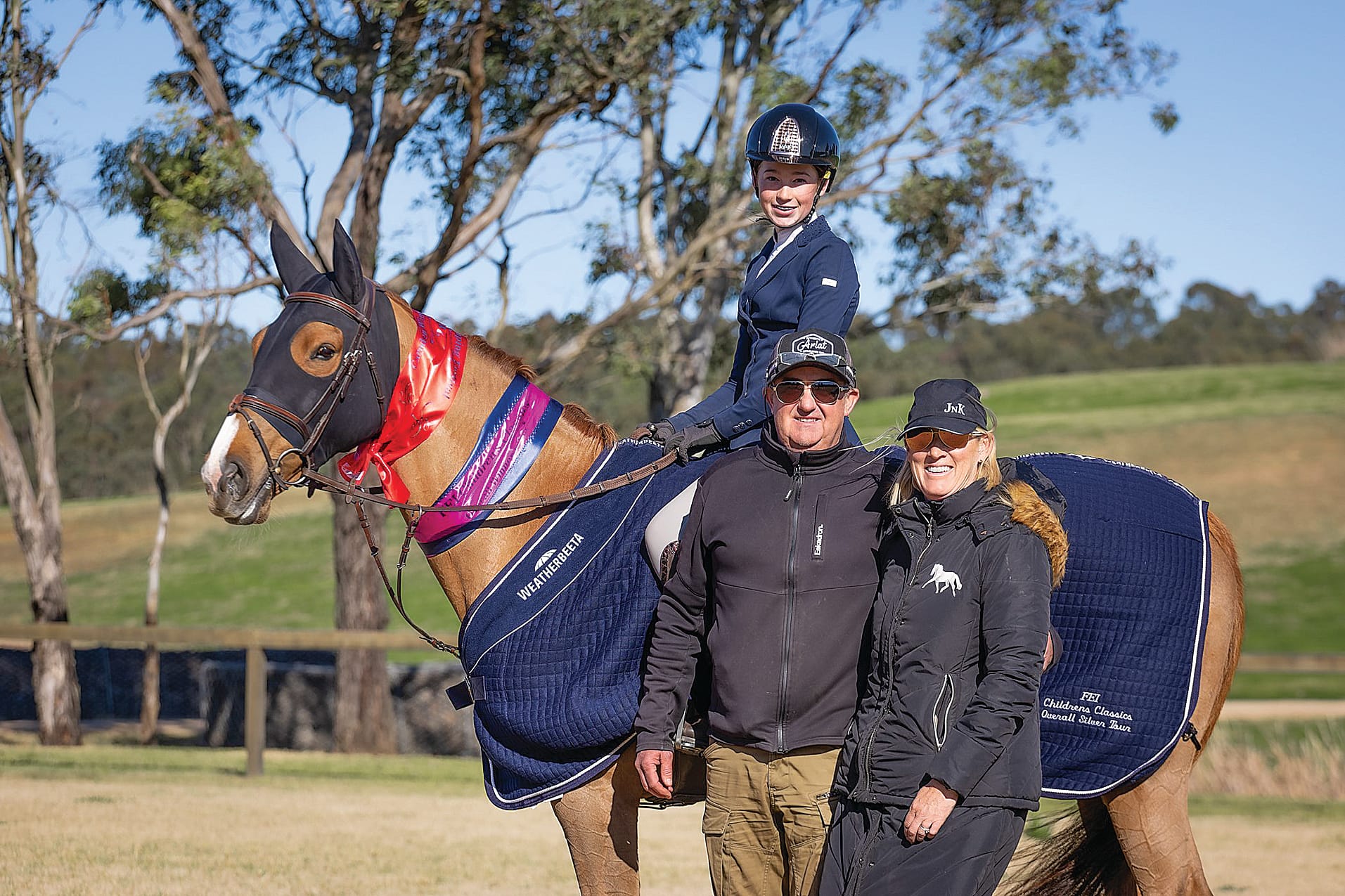 Olivia Curtain with her proud parents following her championship win.