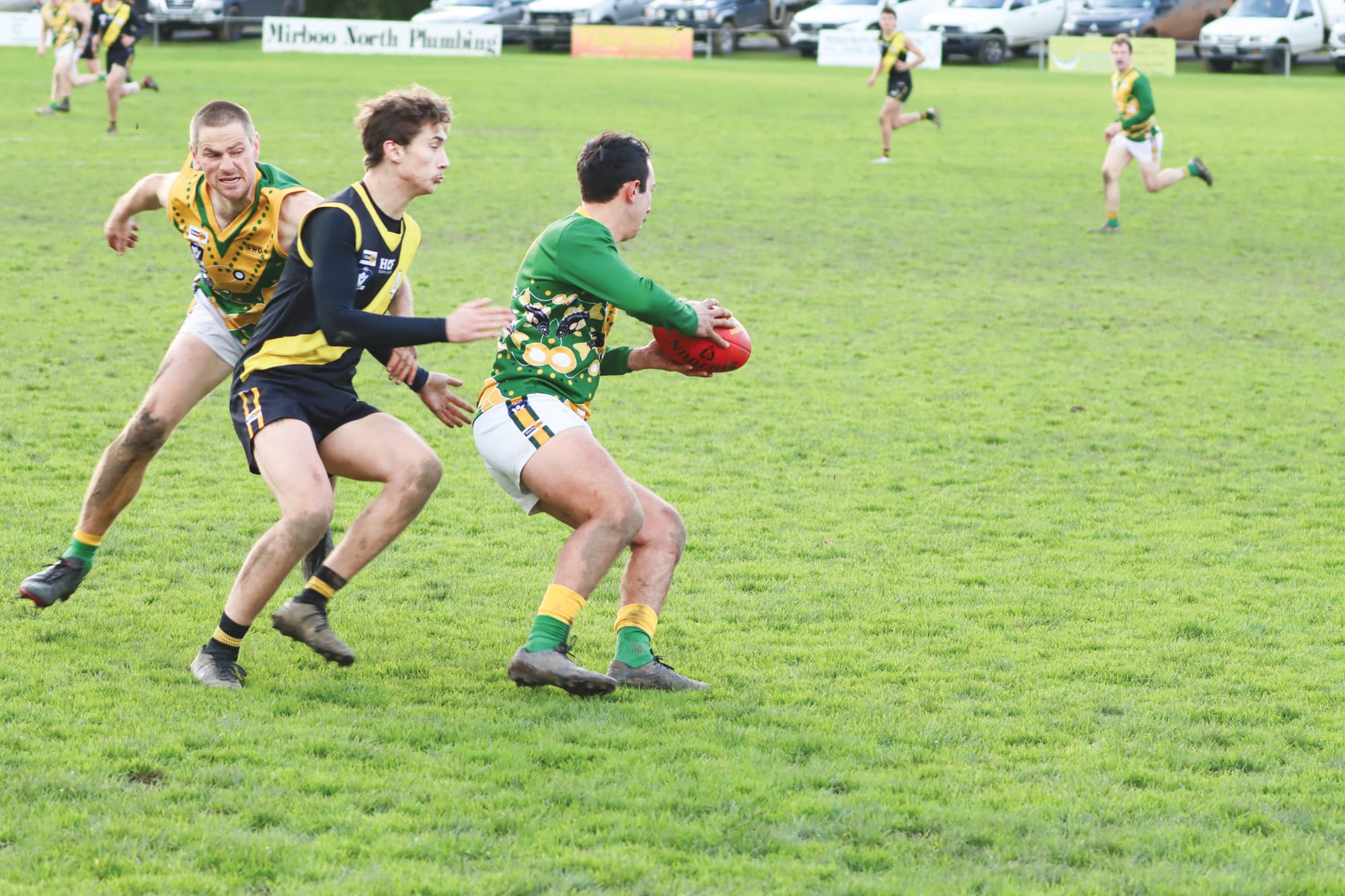 Beau Peters gets set to tackle for Mirboo North but comes in for Hill End attention as he does so. A27_2823