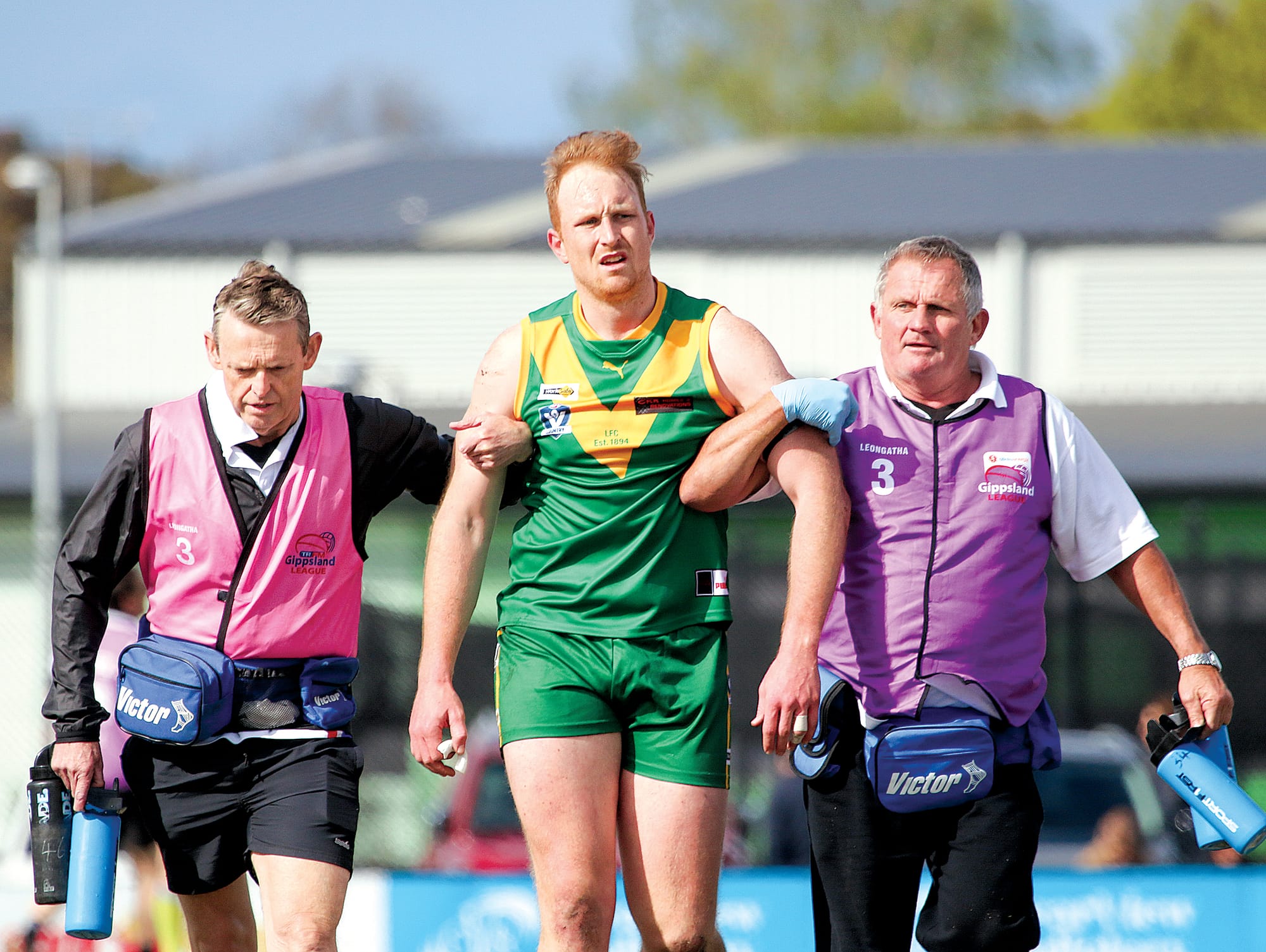 Leongatha trainers Mark Dwyer and Robbie Davies help a dazed Matt Wilcocks off the ground after copping a heavy knock in the first quarter.