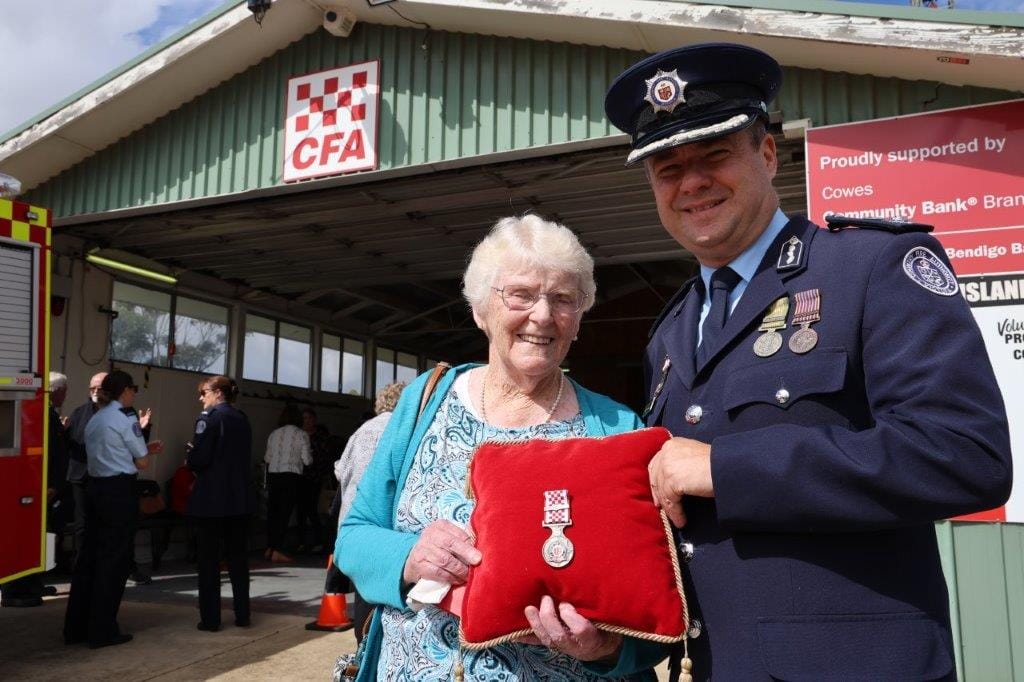 Assistant Chief Officer of the CFA Trevor Owen presents the 75-year CFA service medal to wife of the late Artie Murdoch, June, at his funeral on Tuesday.