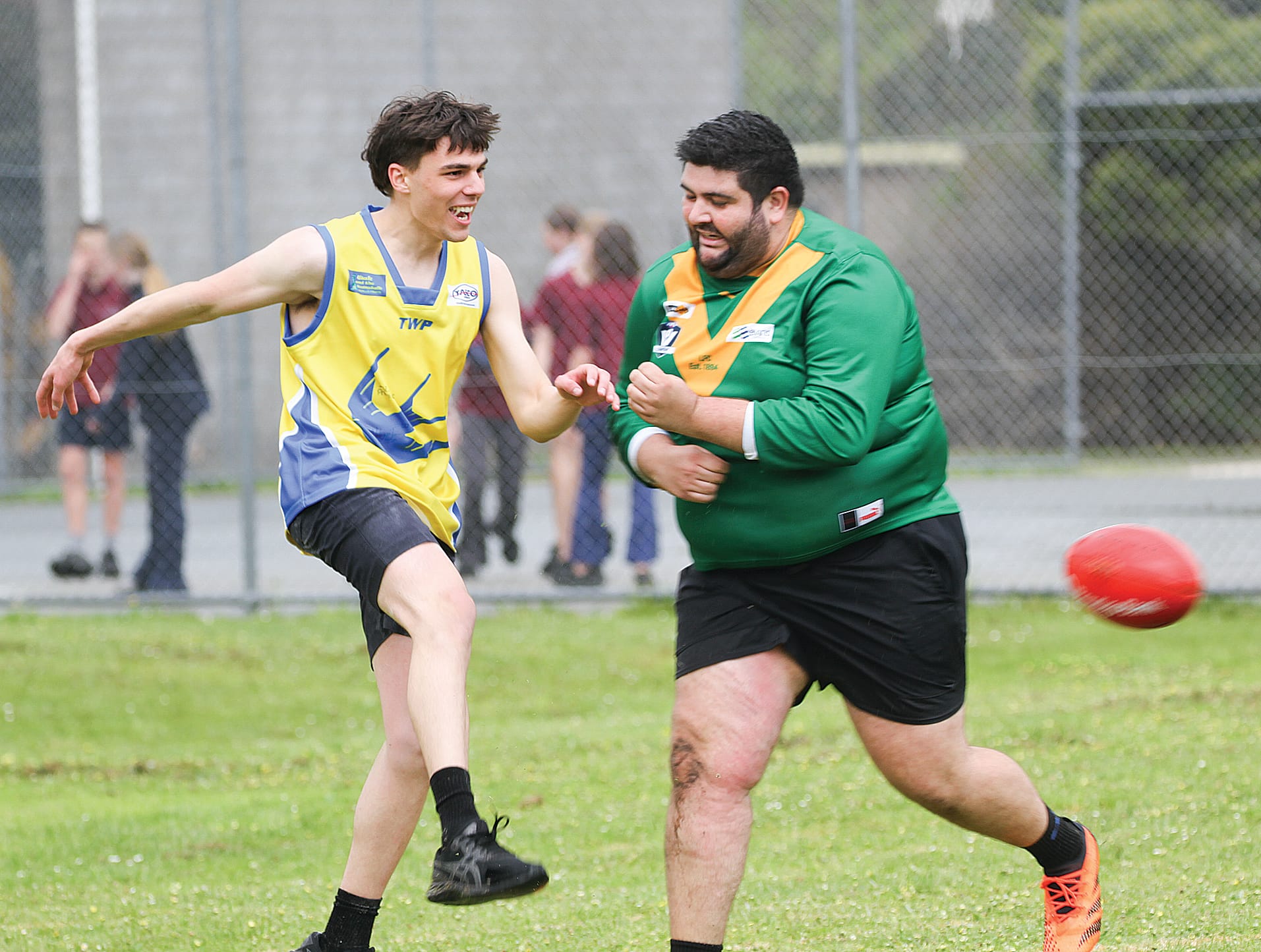 Foster Secondary College Year 12 student clearing the ball under pressure. B25_4424