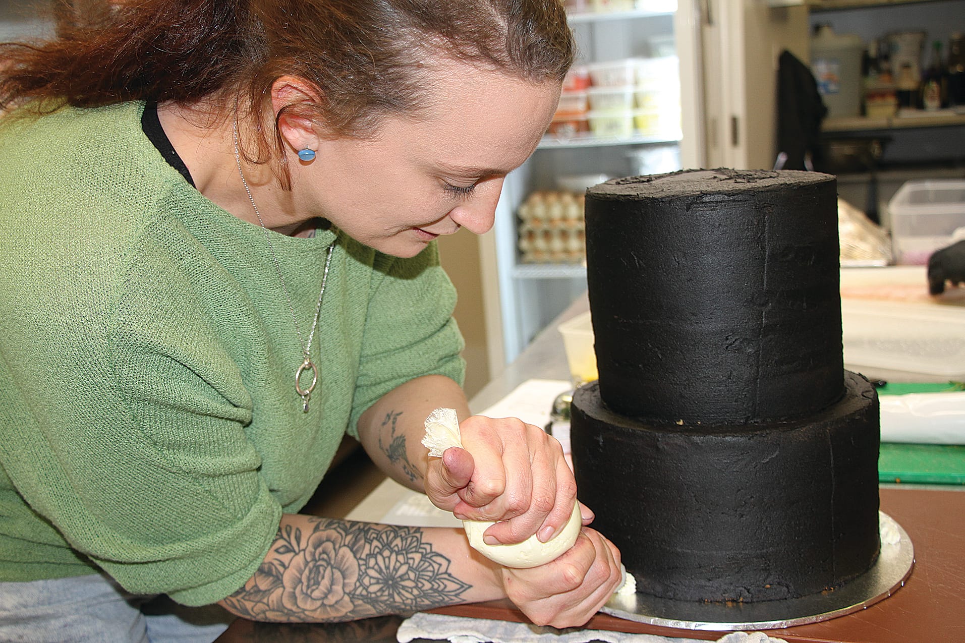 Nicole Pearson from State Coal Mine Café decorating the Friends of the State Coal Mine 40th anniversary cake.