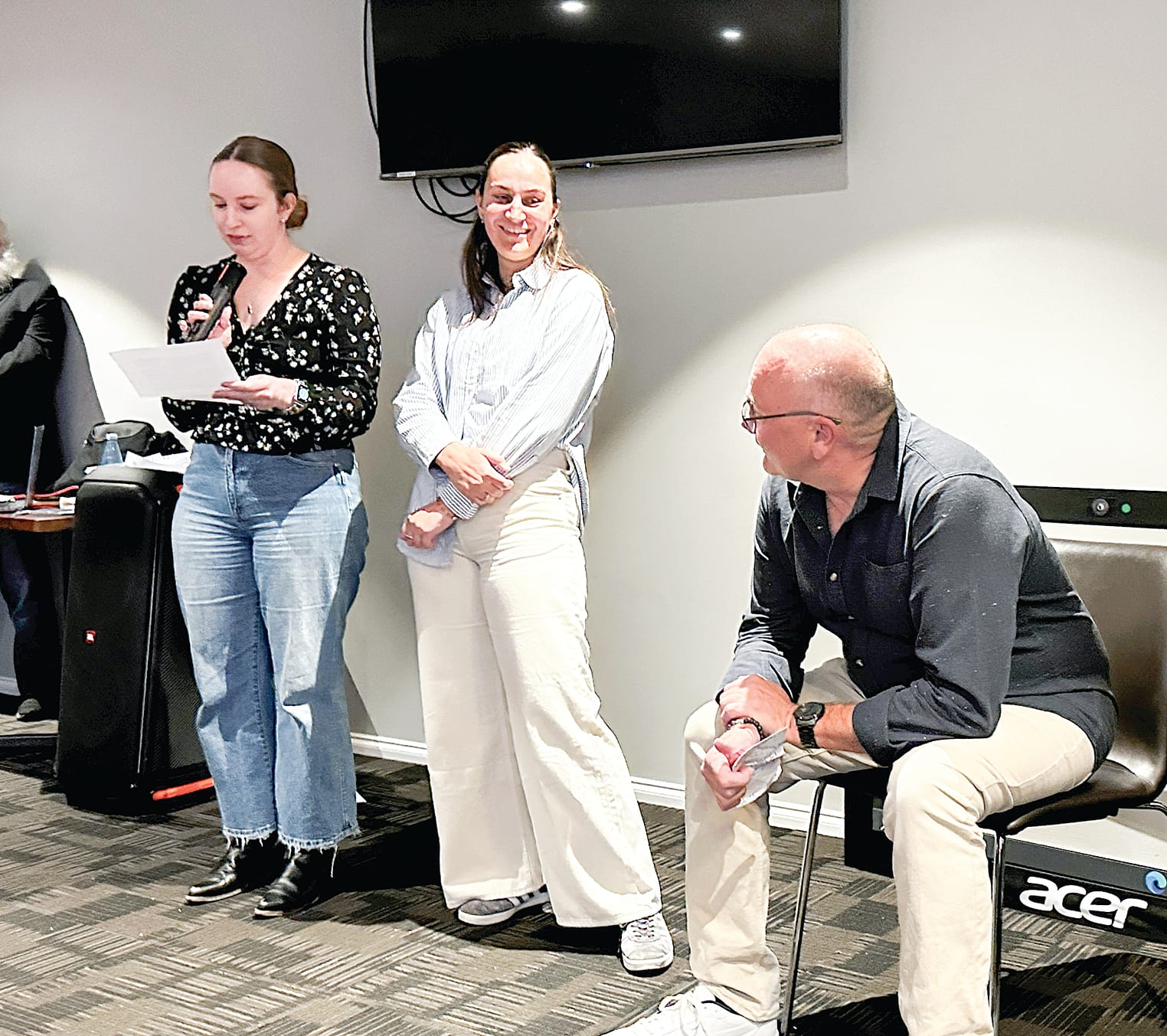 Former Bass Coast College principal Darren listens to daughters Holly and Darcy make a speech at his retirement send-off. 