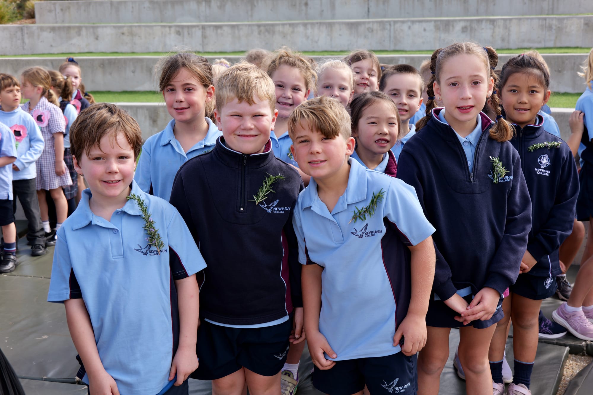 Newhaven College Year 1 students, Raph Innes, Rosie Walker, George Armstrong, Savannah Mol, Archer Ferretto, Harper Guan, Isaac Baker, Chiara Fumagalli and Ellie Chiu, along with their classmates, wear a sprig of rosemary as a sign of remembrance on ANZAC Day commemorations.
