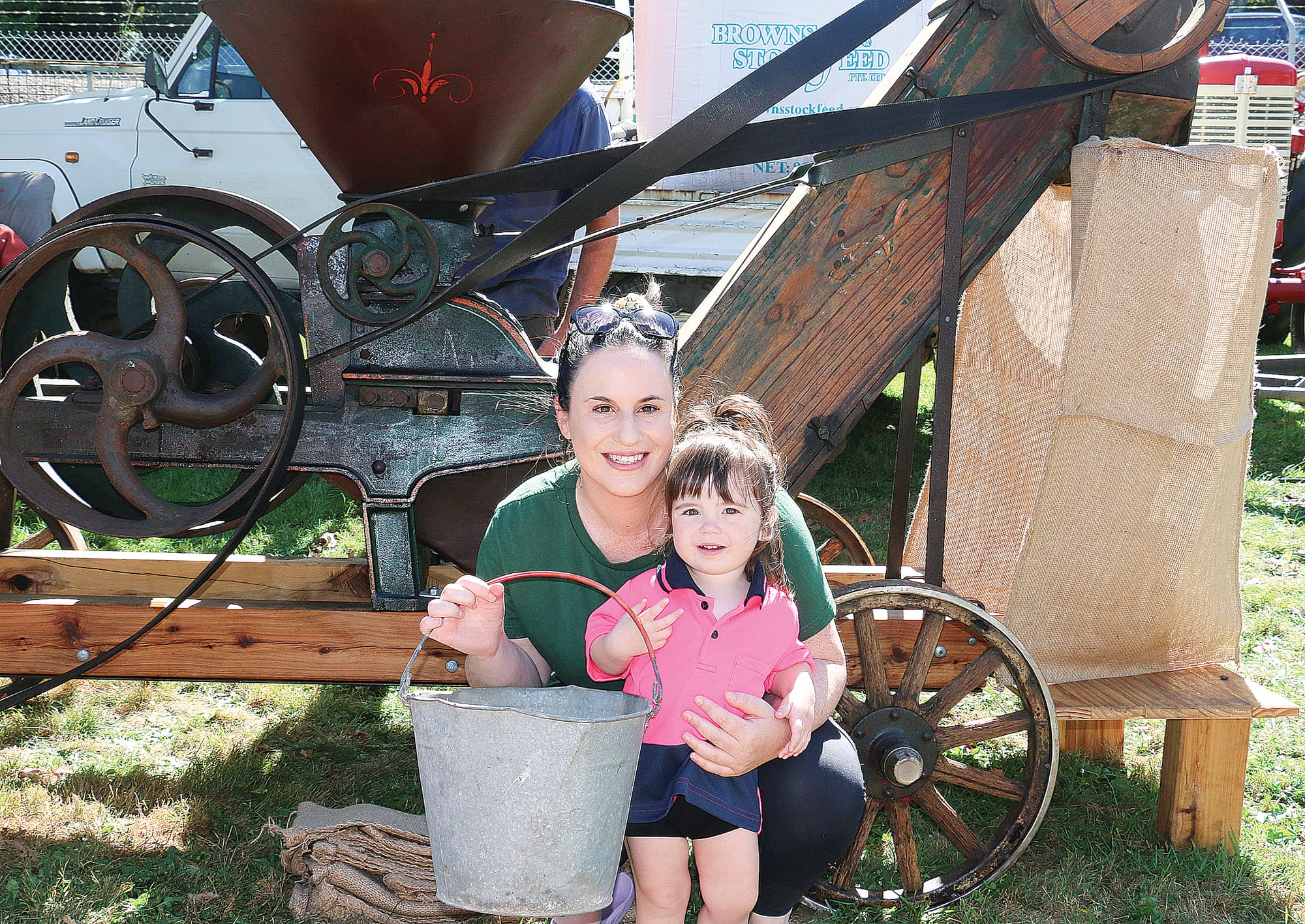 Kate and Ella Wylie with a 1920s grain roller owned by husband and father Adam Wylie.