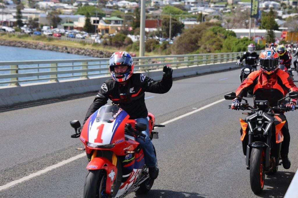 Mick Doohan gives the crowd a wave as he heads off across the San Remo Bridge on the Home Coming Ride ahead of the Phillip Island MotoGP at the weekend.