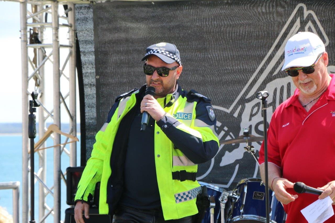 Acting Sergeant Scott Simcock takes over the microphone from Zaidee's Rainbow Foundation founder Allan Turner at the Blessing of the Bikes to deliver an important road safety message.