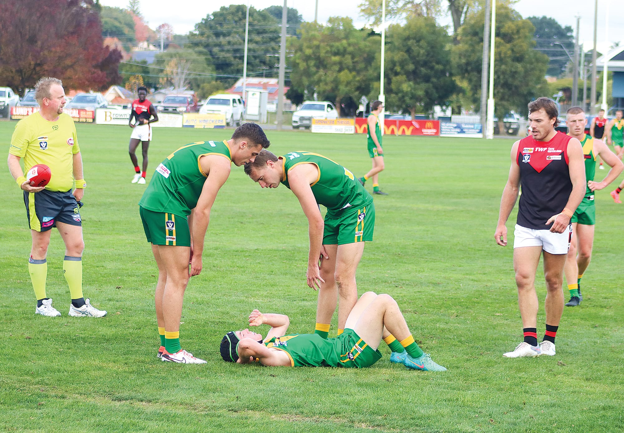 Jake van der Pligt and Jack Hume check on the welfare of Leongatha teammate Ned Hanily. A15_1924