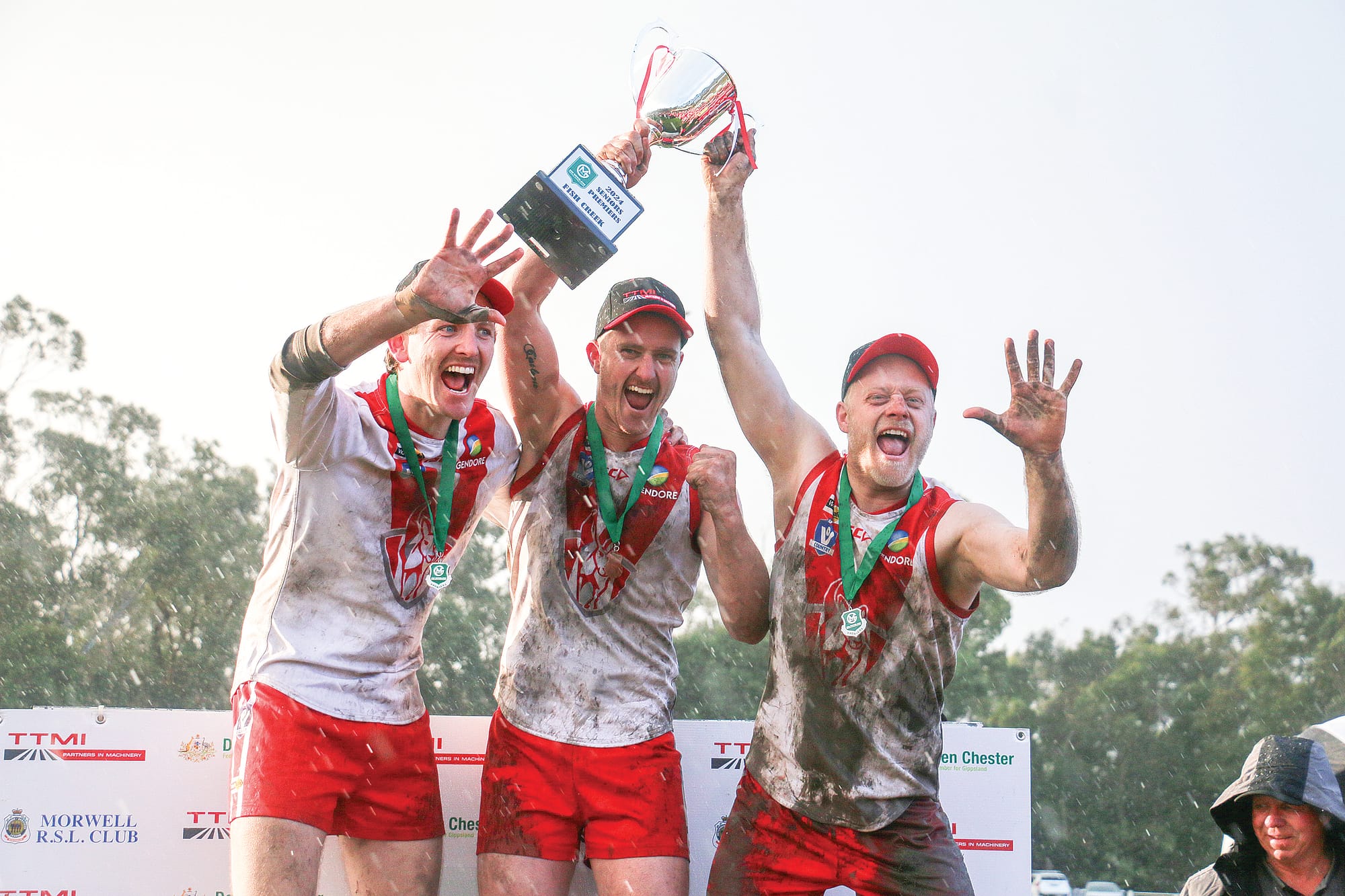 Jack Hayes, Jarrod Walker and Tom Cameron claim the cup for Fish Creek following their Senior premiership win. tk32_3824