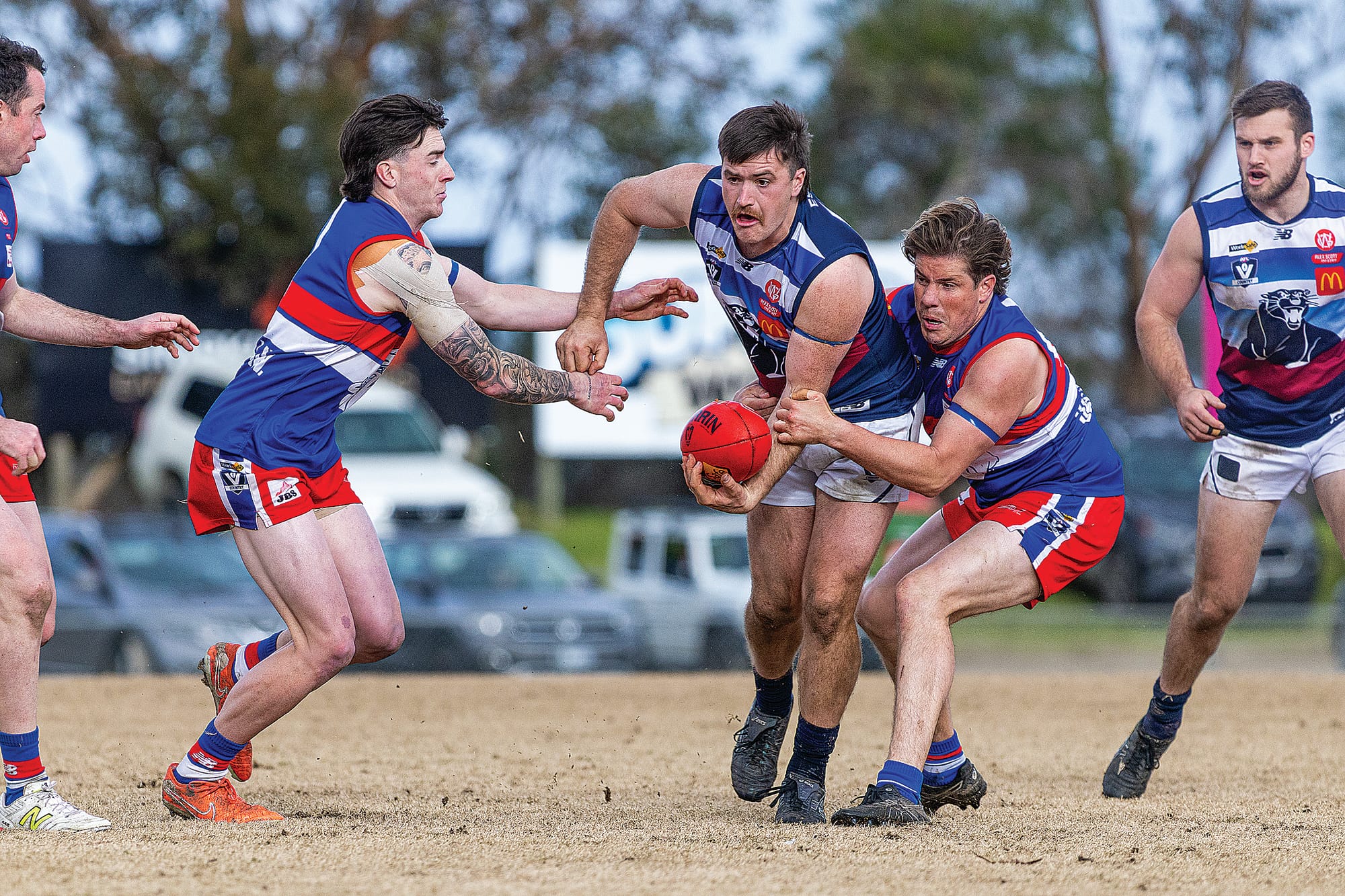 Lachlan Burns feels the heat from both sides as the Bulldogs applied the pressure. Photos: Bec Casey Sports Photography.