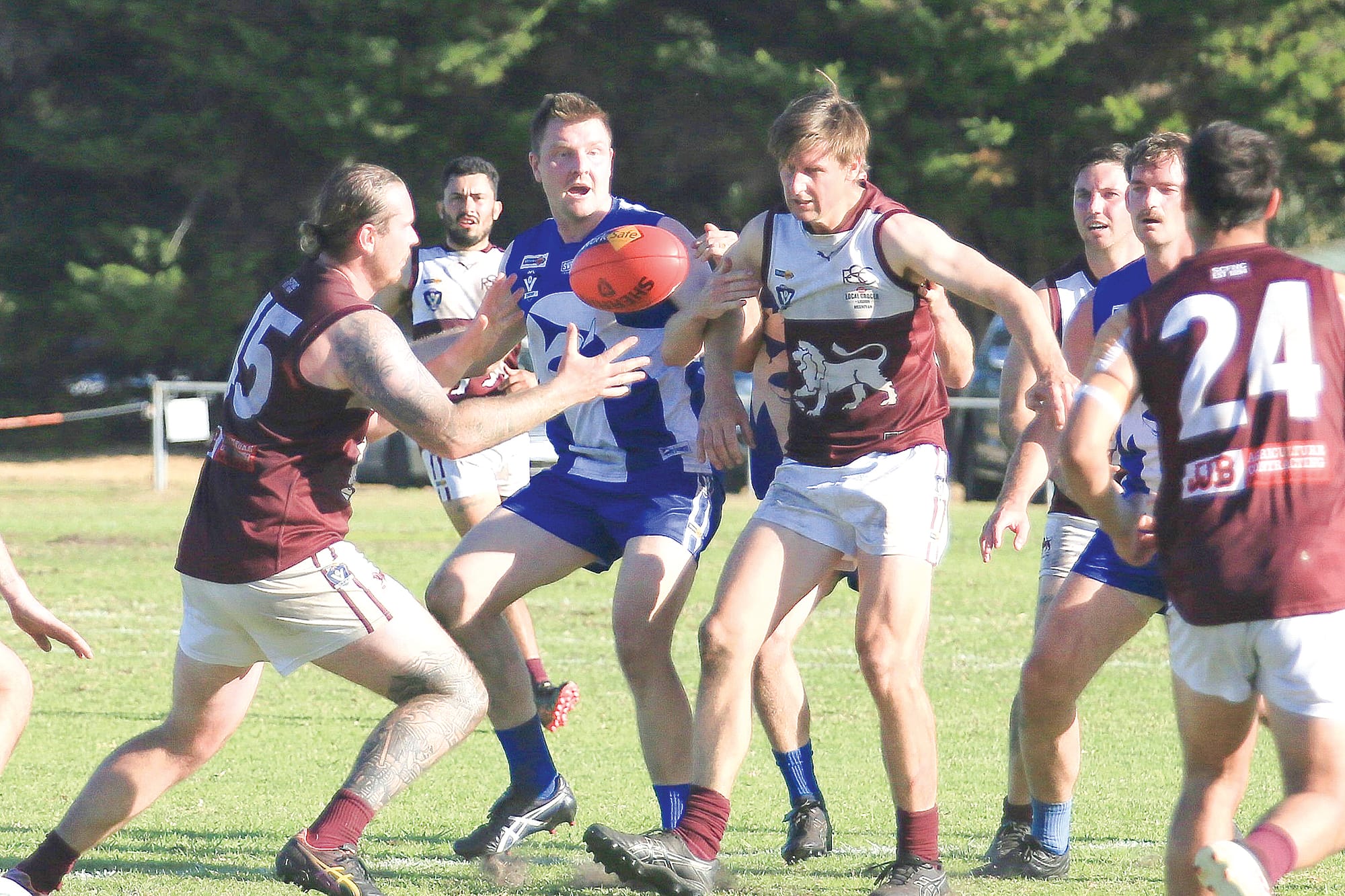 Jayden Battersby, Jordan Staley, and Chris Verboon move in to contest the football.