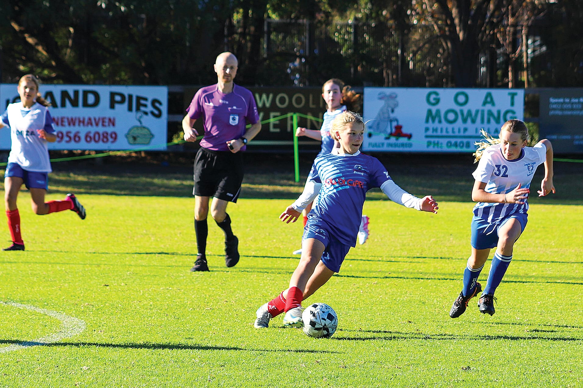 Phillip Island’s Hannah pressured by Leongatha’s Samara in midfield during the U15 Girls Game. 