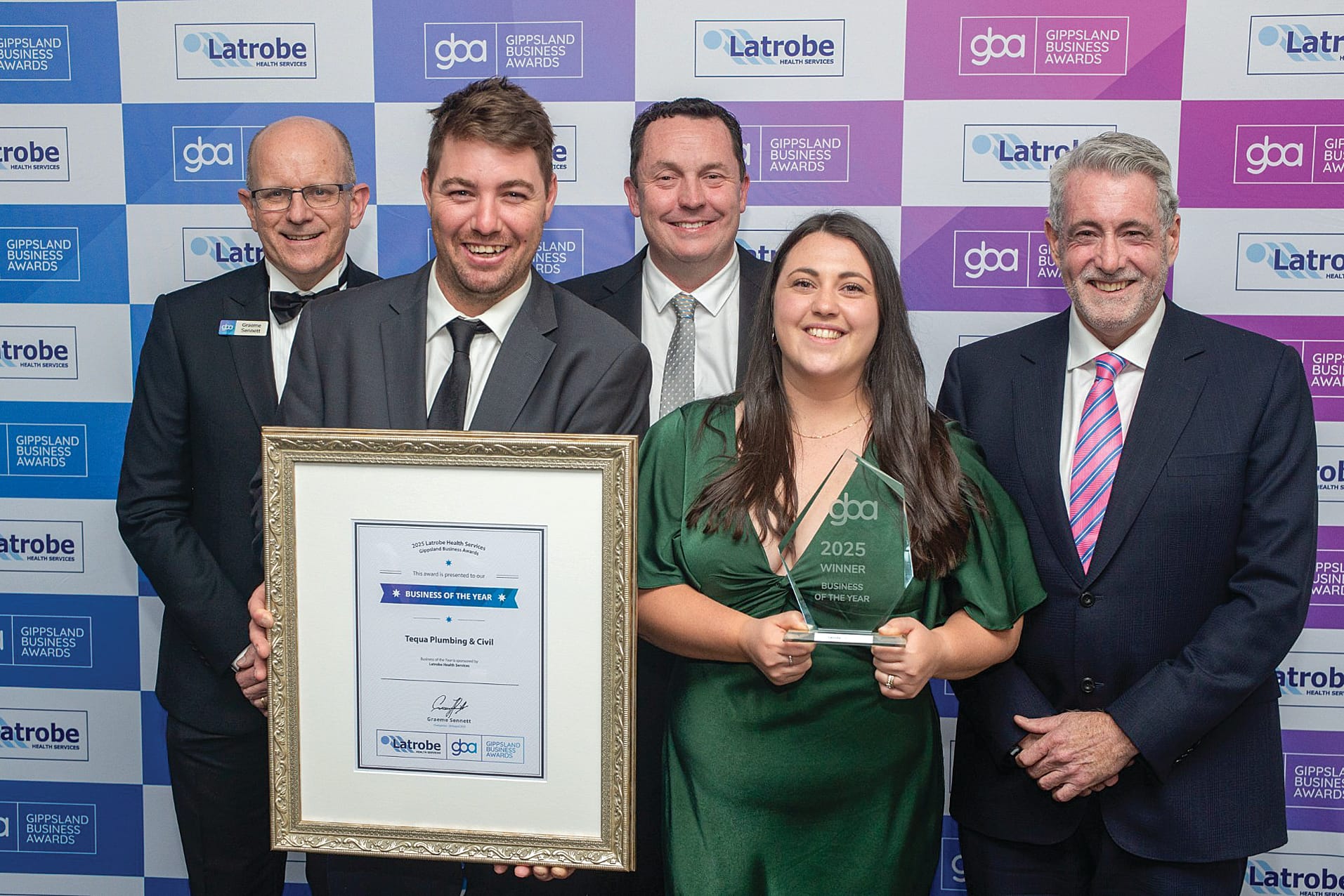 Latrobe Health Services CEO Ian Whitehead (right) is pictured with Gippsland Business Awards Chair Graeme Sennett (left) presenting CEO Trent Fairweather (back), Chloe Milligan and Scott Davey from Tequa Plumbing and Civil in Sale with the Business of the Year award.
