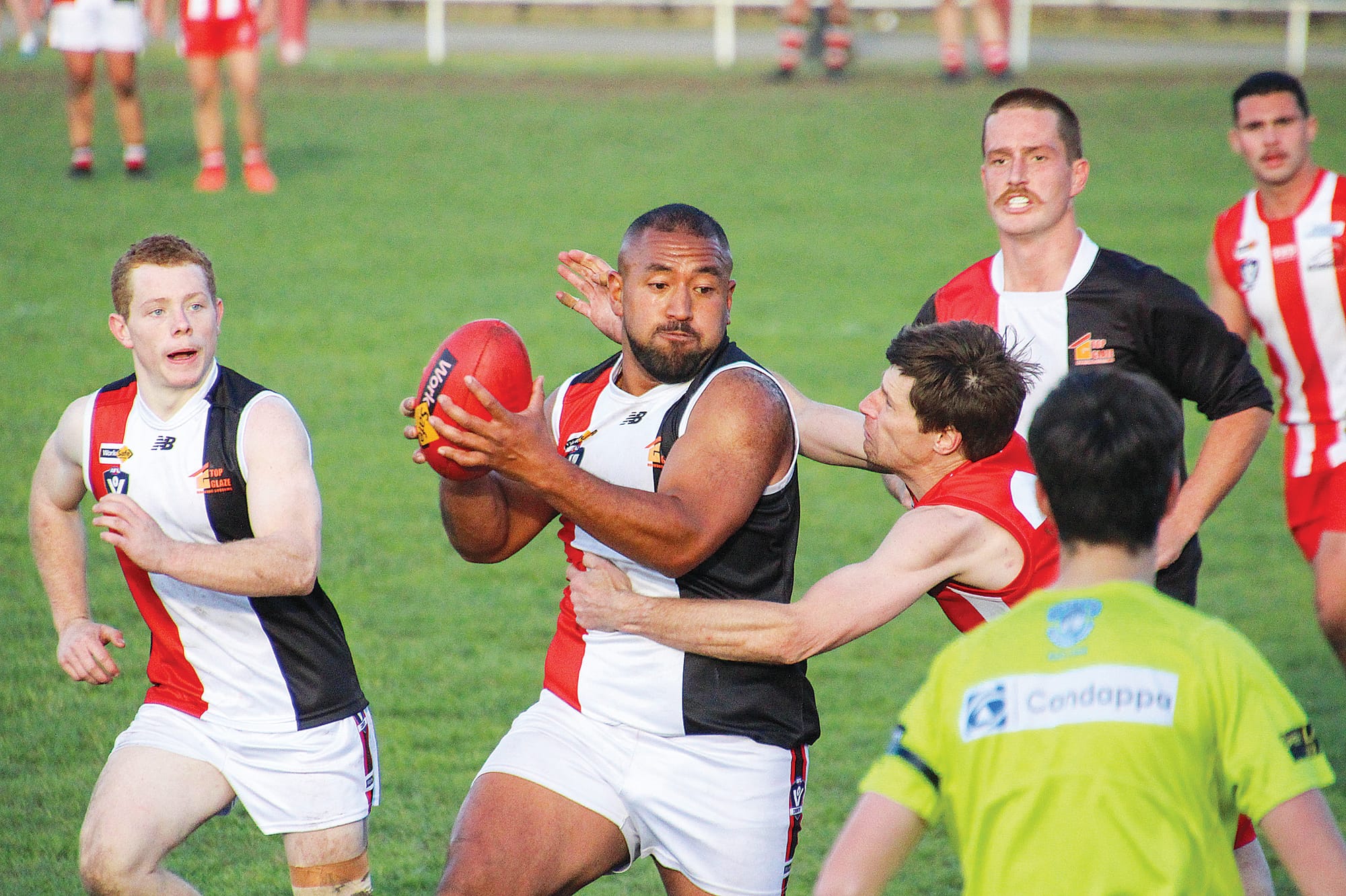 O’Pili Paora attempts to escape the clutches of his Trafalgar opponent.