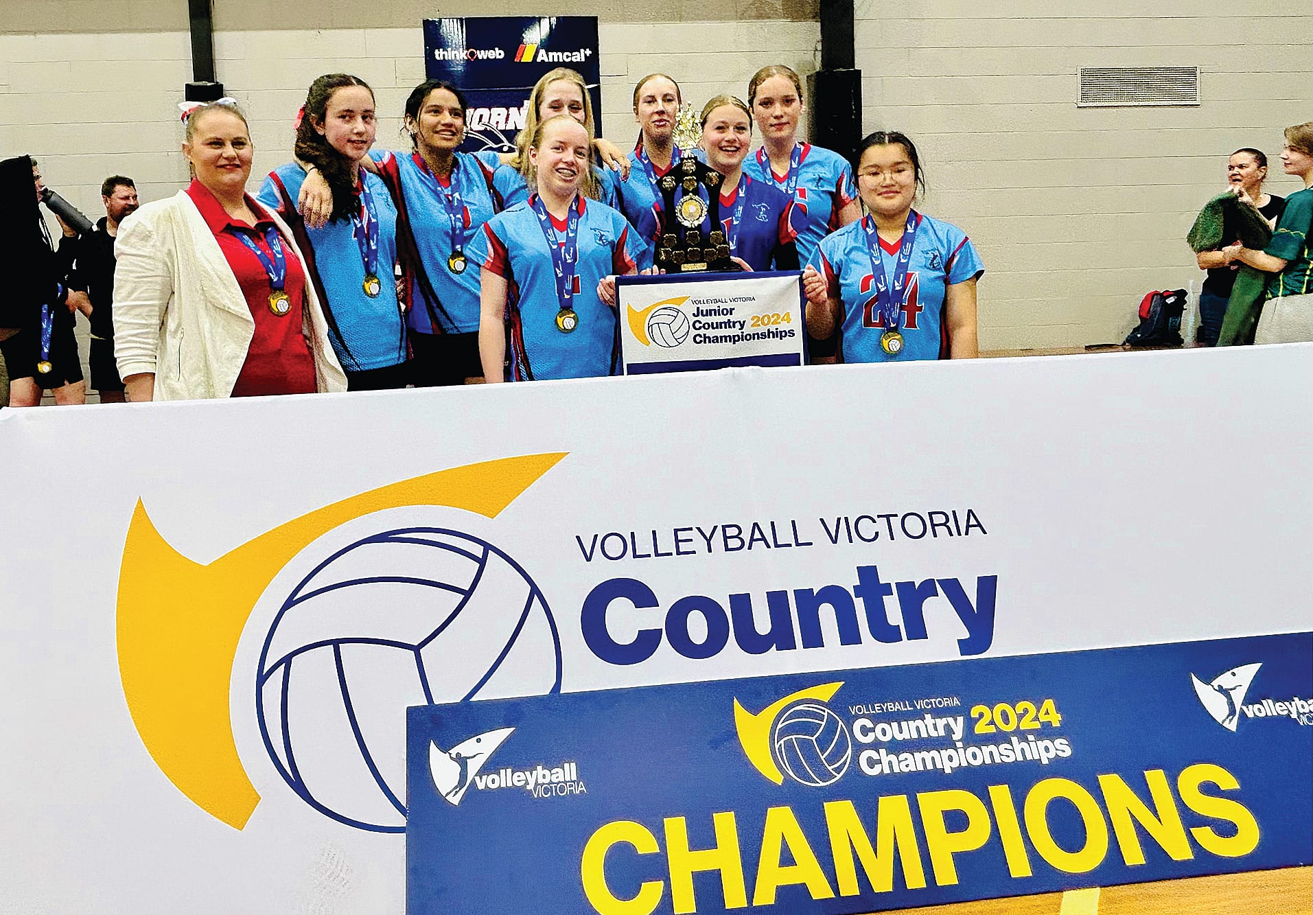 Coach Tamara Miller celebrates with the winning U17s team of Amelia Hams, Ayoshe Herbert, Casey Slater, captain Natalie Churchill, vice-captain Georgia Mills, Jessica Churchill, Georgia Scarce and Yasmin Gloria.