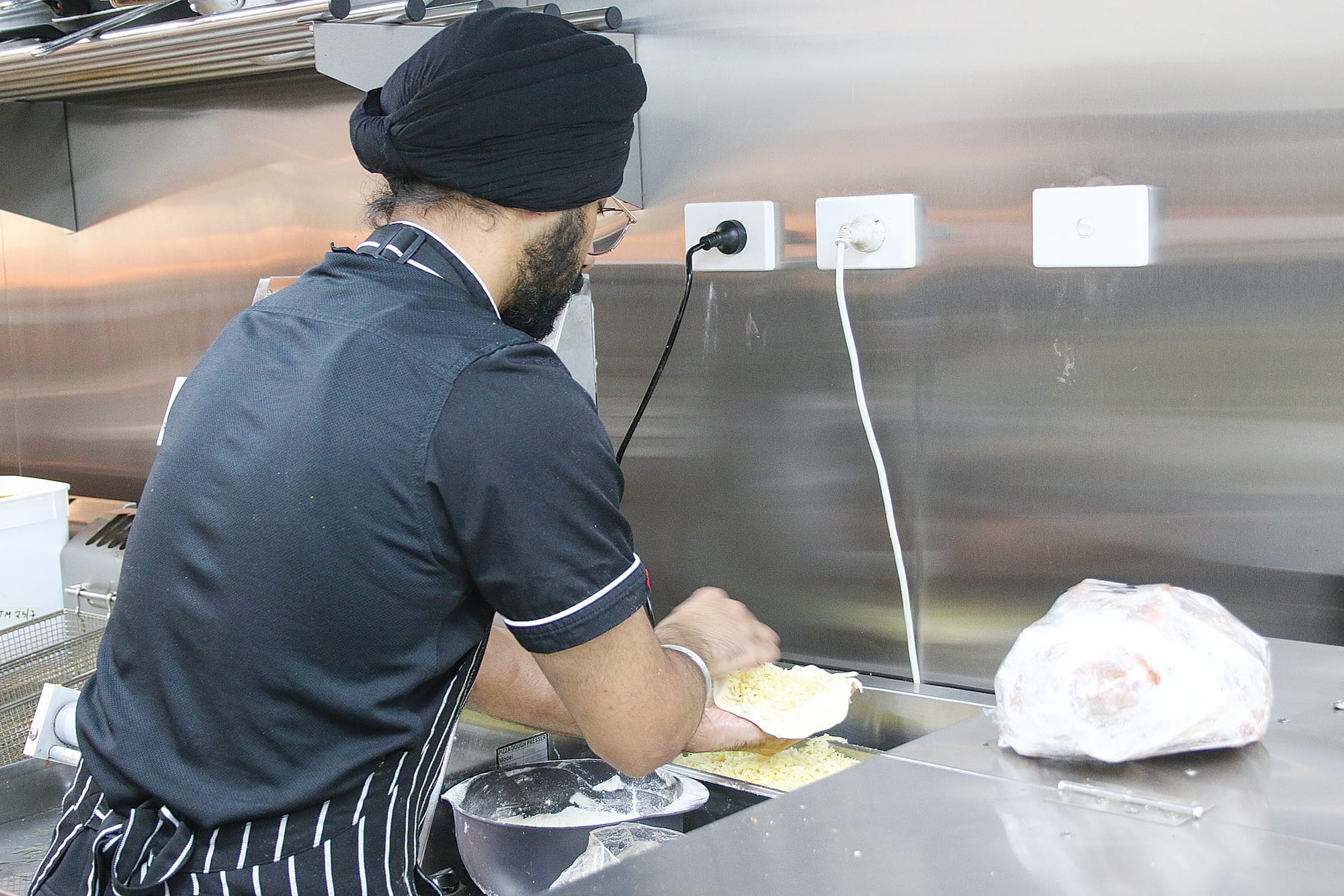 Noor fills a cheesy naan. C04_3025