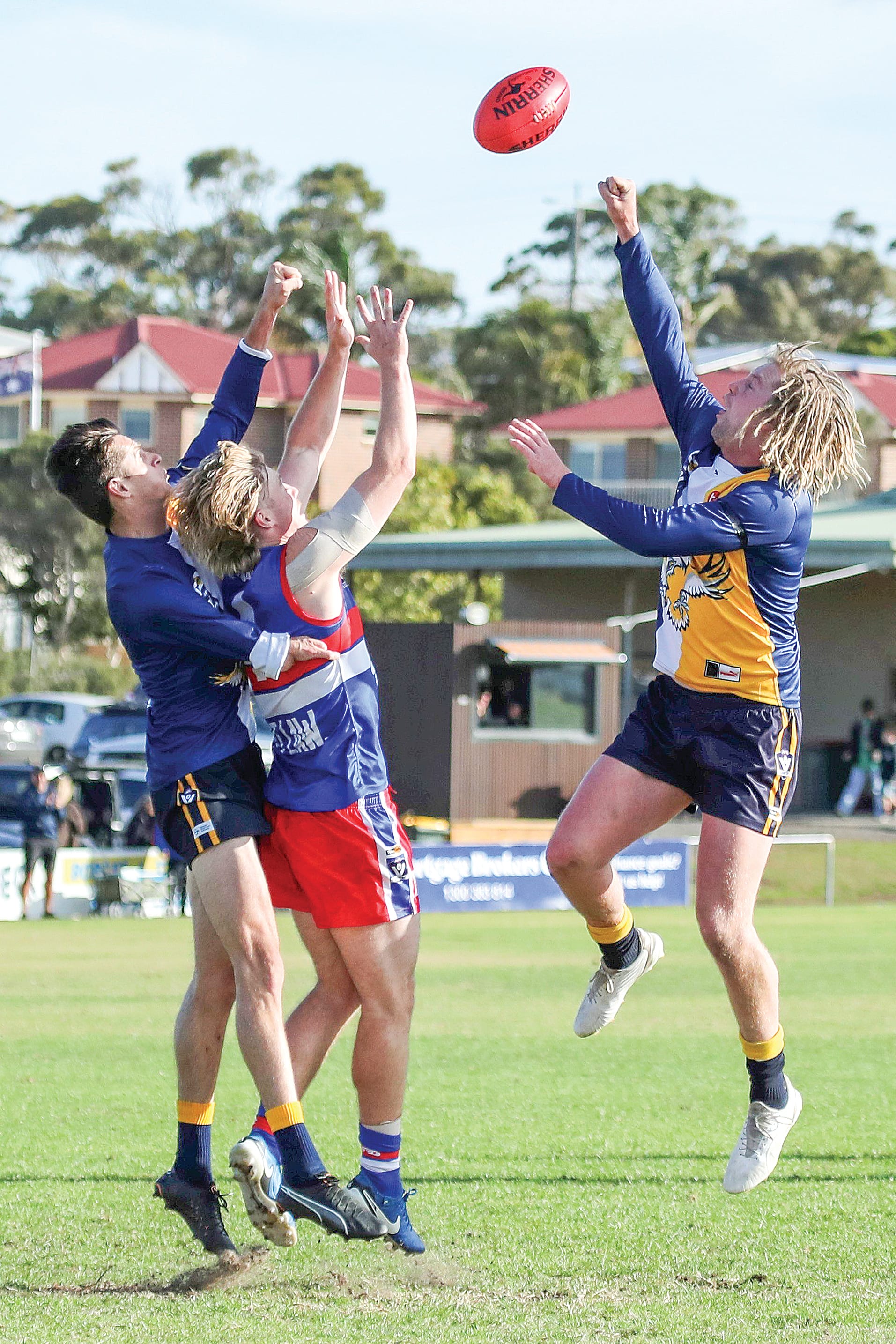 Phillip Island’s Charlie Bruce battles a couple of Inverloch-Kongwak opponents during the Bulldogs’ commanding 100-point win, Bruce finishing with a couple of goals. Photo: Carol Ratcliff.