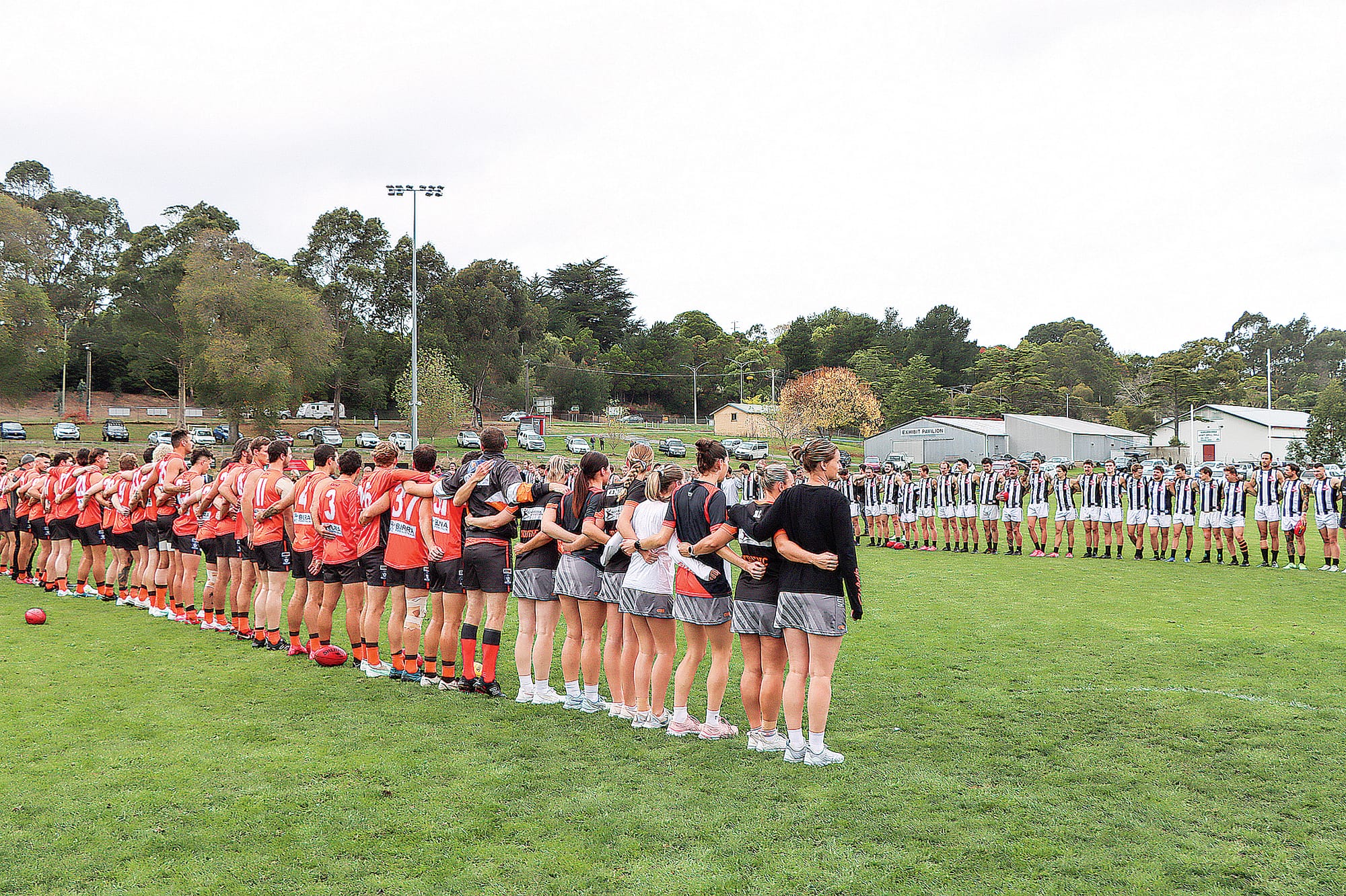 Players await the Anzac Day service. A26_1725