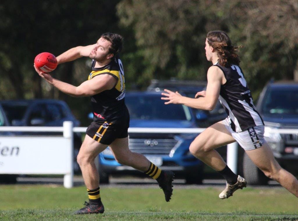 Foster’s Josh Toner, getting the handpass away, was one of their best in the final at Meeniyan on Saturday.