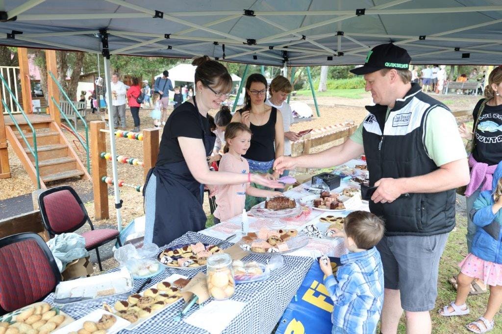 Travis and Ryder Cholmondeley of Leongatha with volunteers Charlotte Mortimer and Carly Buckland at the Fish Creek Primary School cake stall at the Fishy Stories Festival last Sunday.