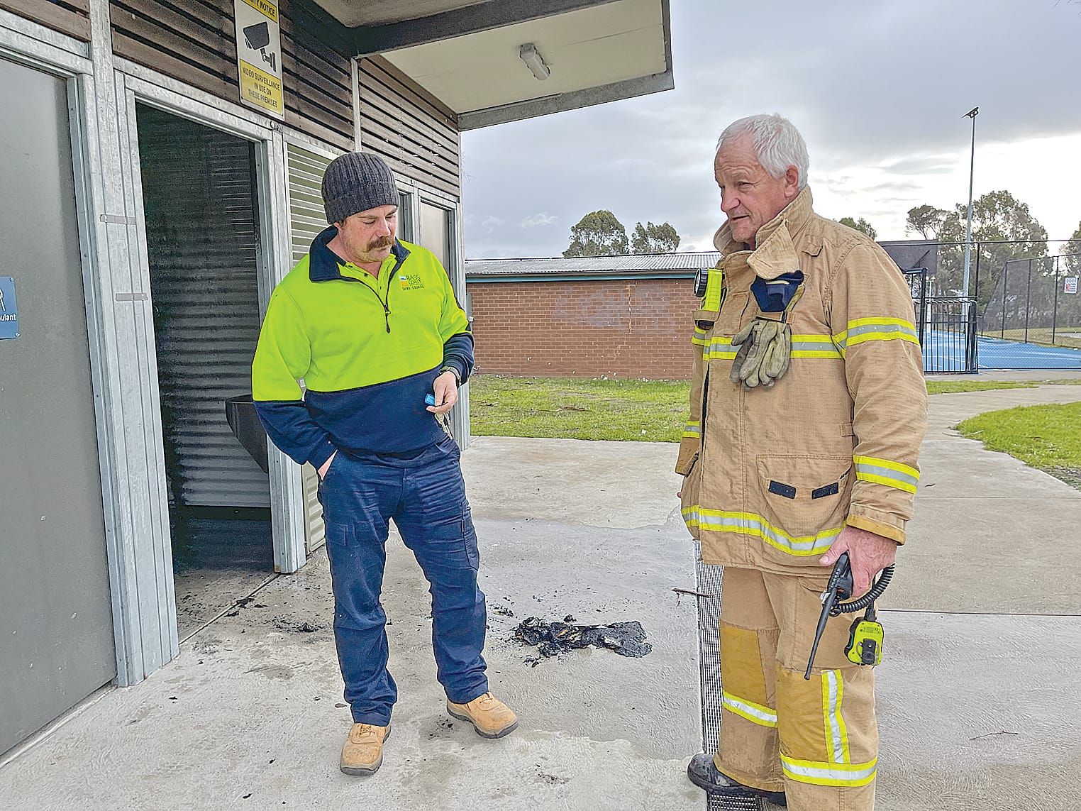 Steve of Bass Coast Shire Council Open Space Maintenance discussing the fire in the toilet block at the Harold Hughes Reserve in the centre of Corinella with Corinella CFA member, Mick Hamilton. Photo: Meryl Tobin.