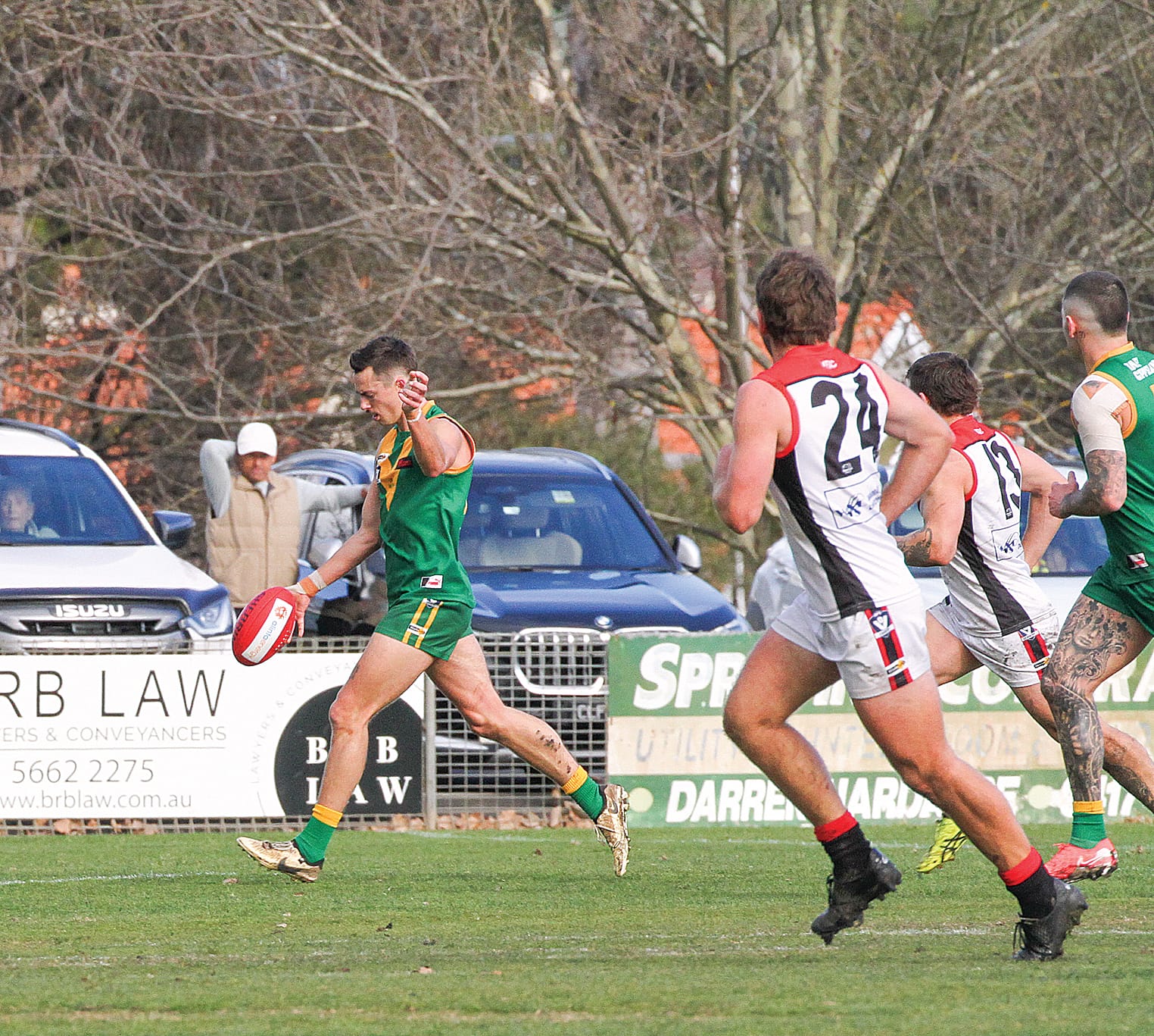 Travis Nash concentrates on his delivery as Parrot legend  Peter Helms watches from the other side of the  boundary.  B117_3125