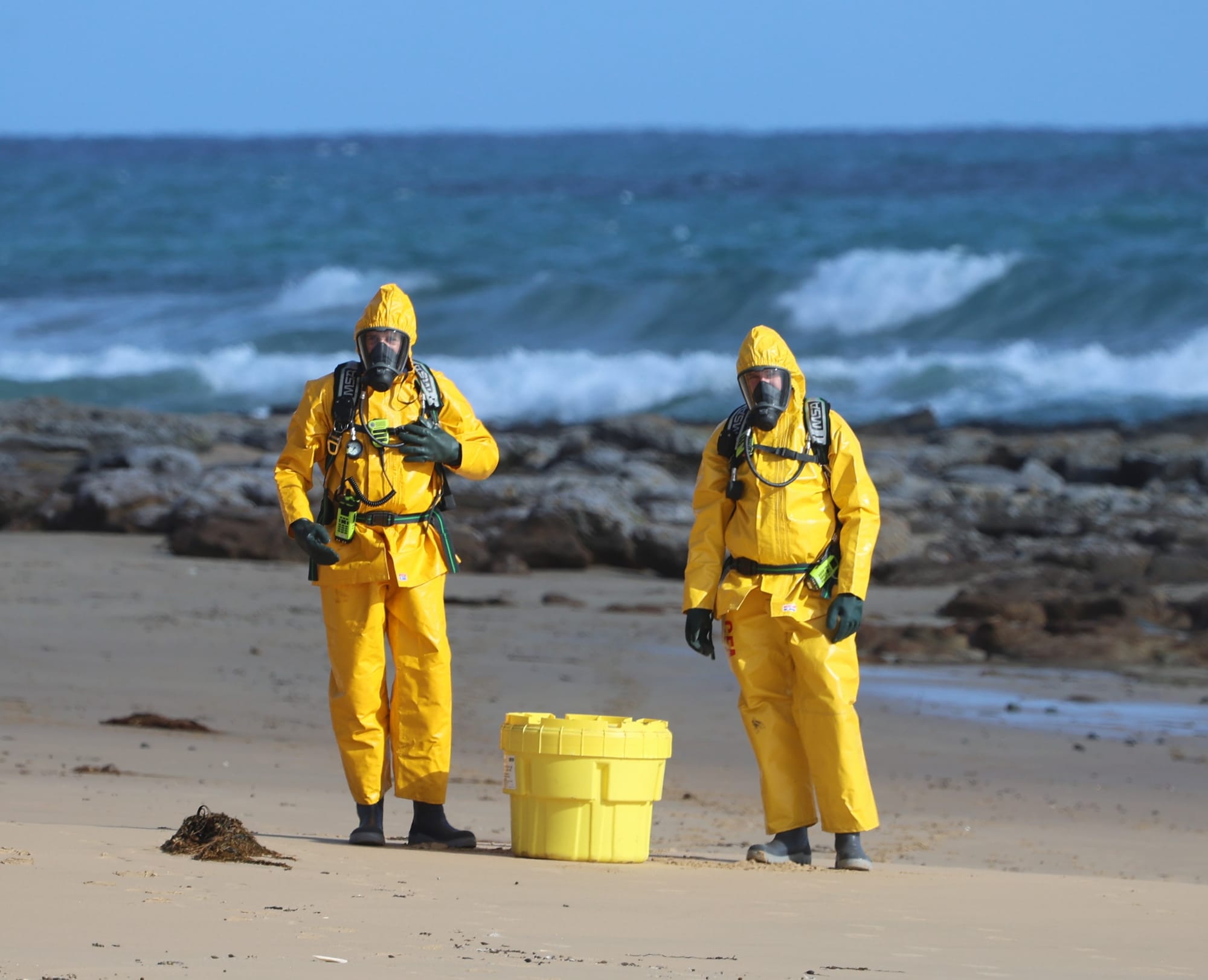 HAZMAT trained firefighters from Wonthaggi back on the beach after recovering a potentially hazardous drum of phosphoric acid from the rocks at Surf Beach on Phillip Island.