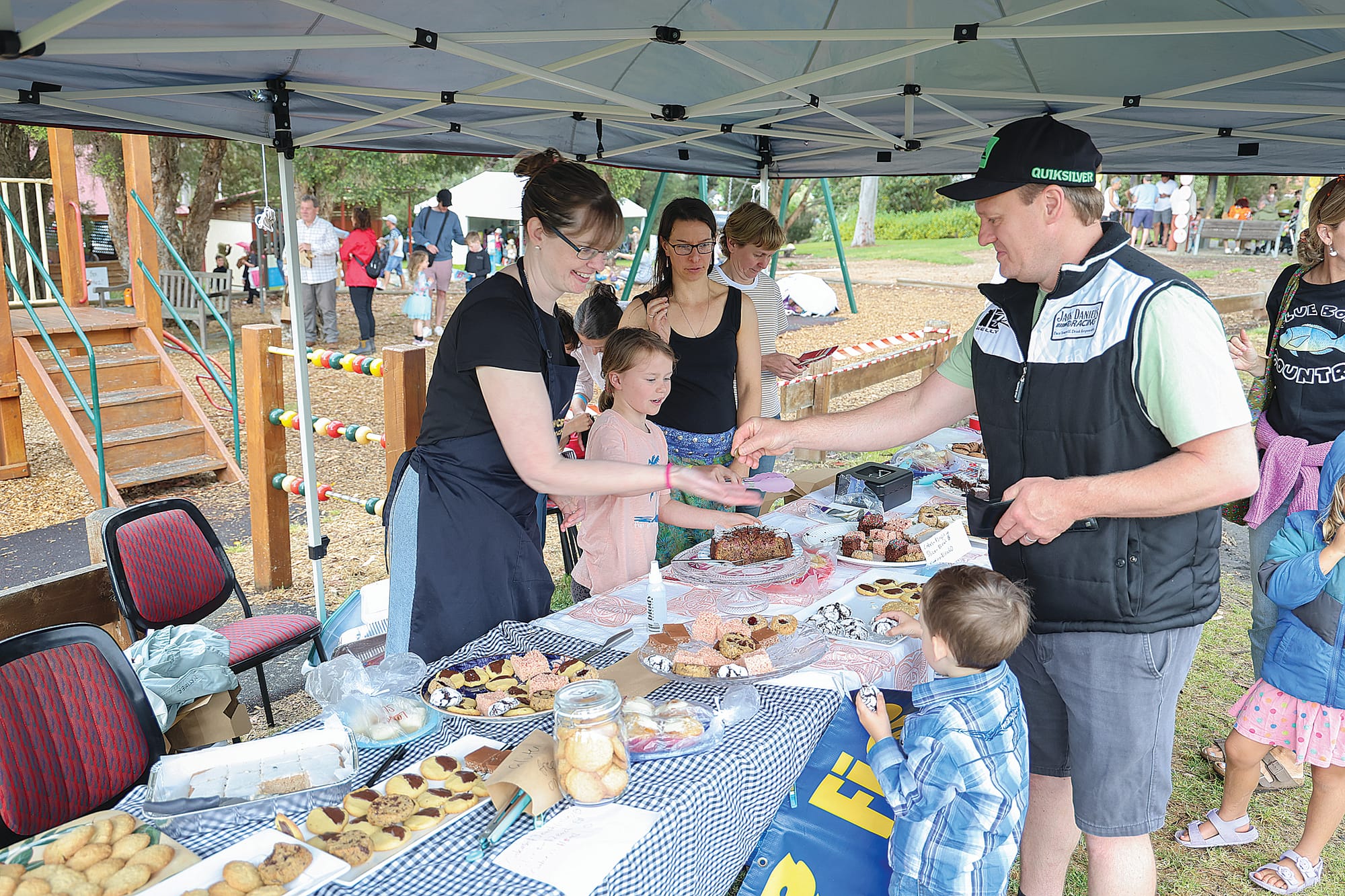 Travis and Ryder Cholmondeley of Leongatha with volunteers Charlotte Mortimer and Carly Buckland at the Fish Creek Primary School cake stall at the Fishy Stories Festival last Sunday.