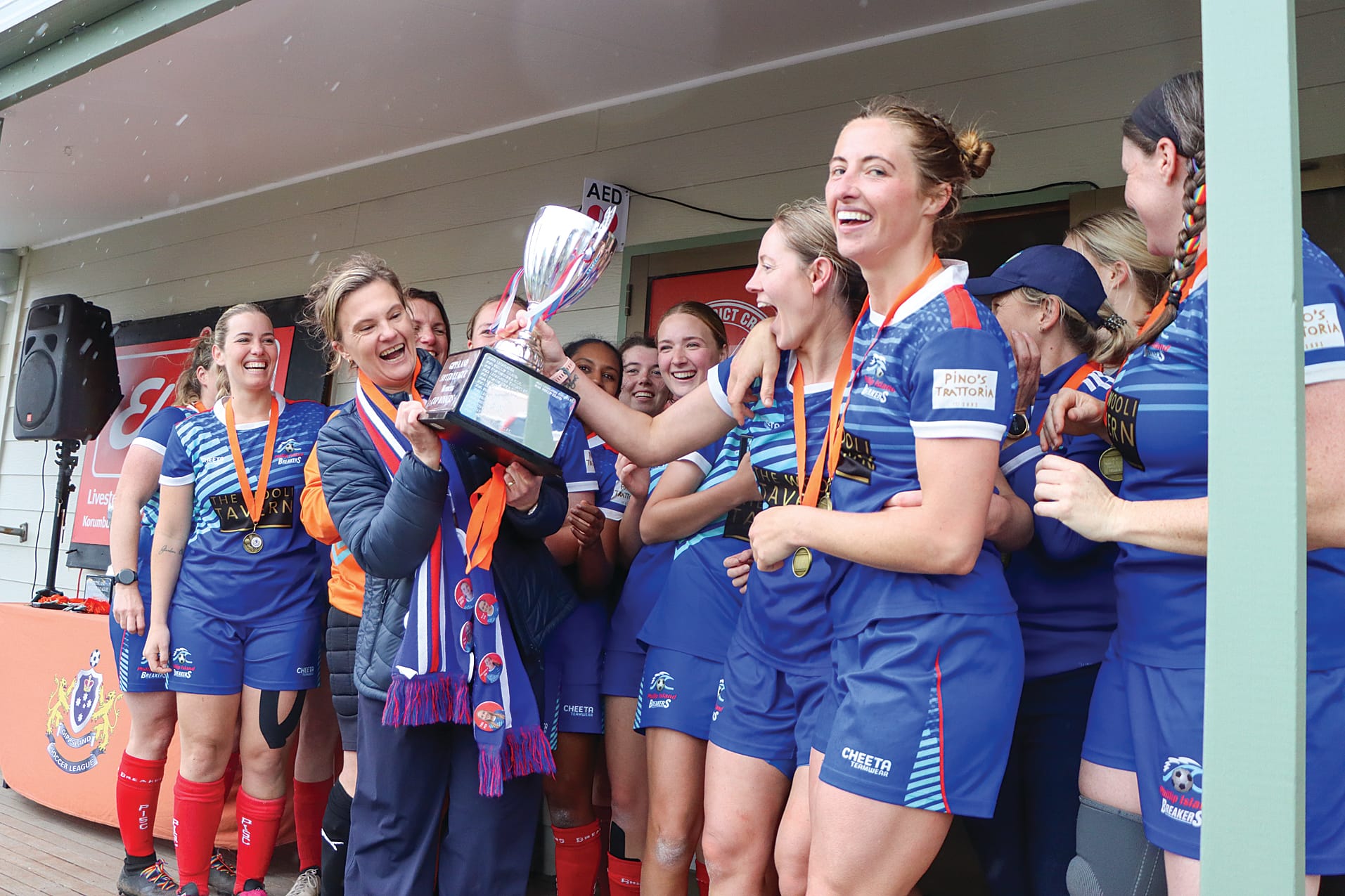 Phillip Island skipper Kelly Wall holds the Premiership Cup as teammates join the celebrations. A63_3825