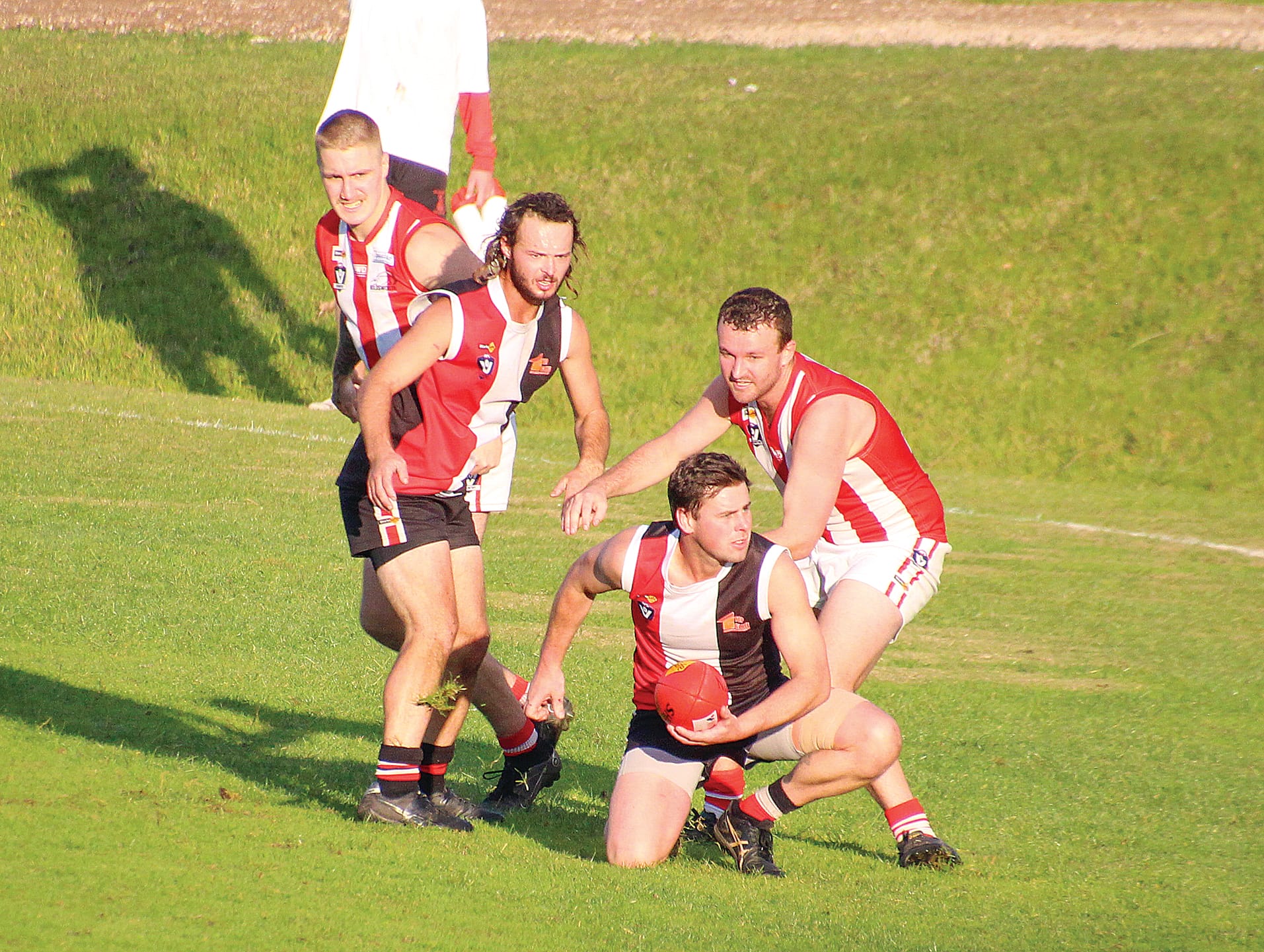Sam Dixon makes the handball before being caught. 