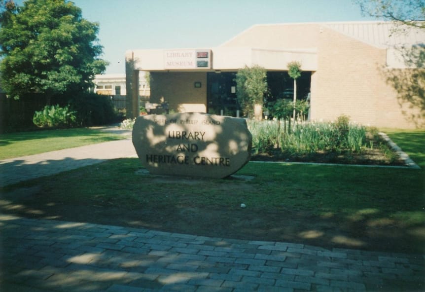 Colour photograph of the Cowes Library and Museum in the background with Granite Stone inscribed with