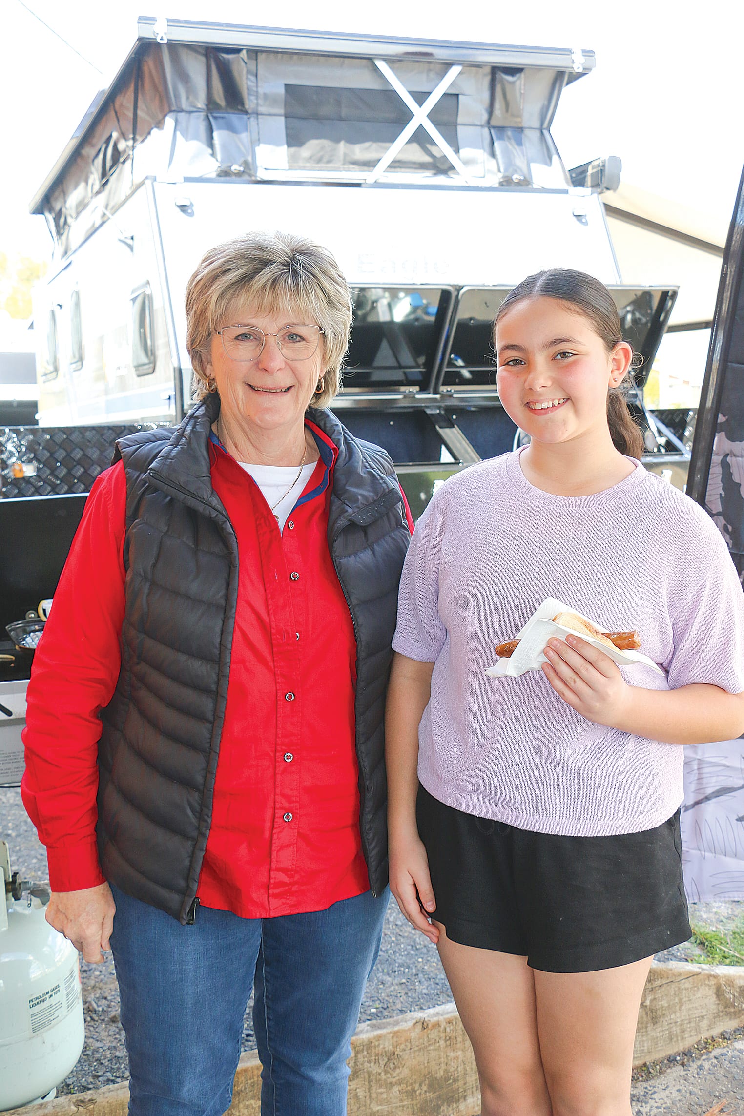 Heather Read ran the sausage sizzle at the South Gippsland Caravans and Camping Centre and is pictured with happy customer Ava Privitera.