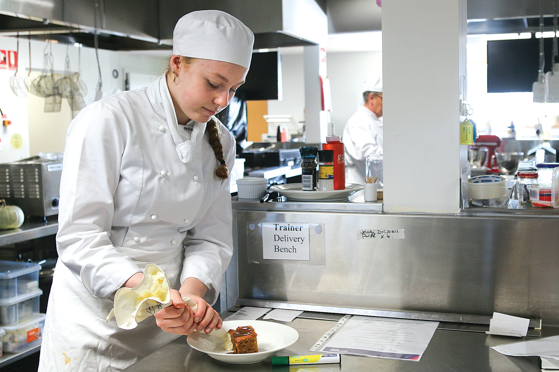 Second year apprentice Zara McKenzie puts the finishing touches to the sticky date pudding. A02_3022