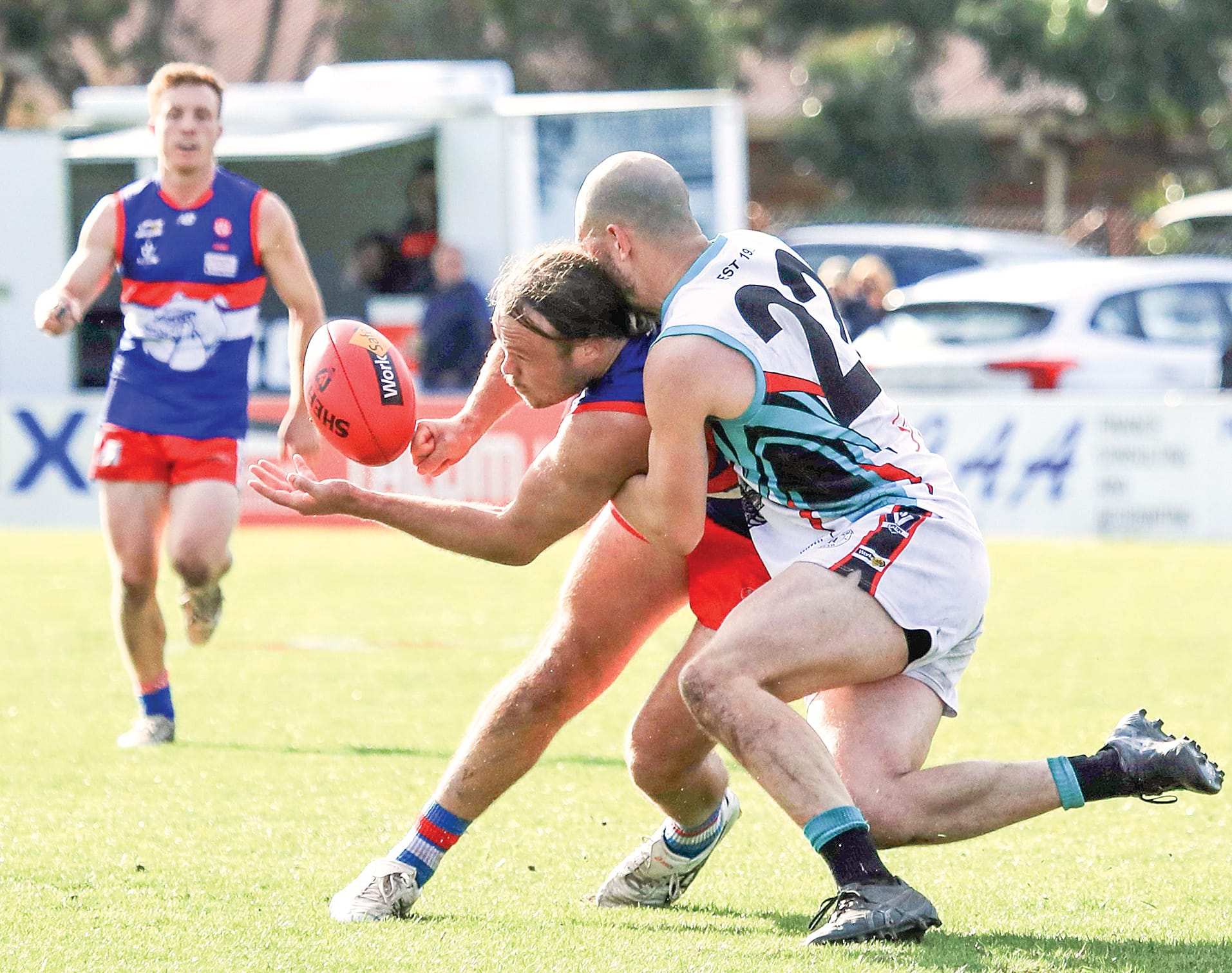 Jack Taylor gets the ball away in the midst of a tackle from Cora Lynn’s Matthew Briggs. Photo: Carol Ratcliff. 