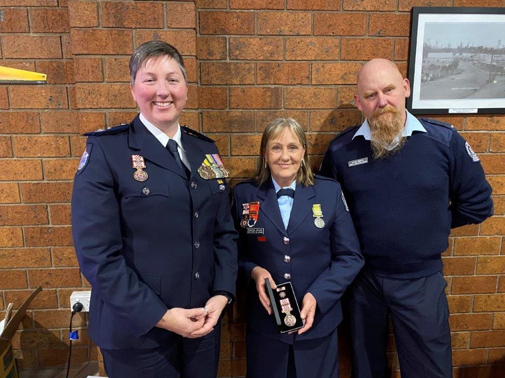 Mirboo North fire fighter Frances Wilson receives his 30-year service award from CFA District 9 Commander Emma Conway and Mirboo North CFA Captain Dave Smith.