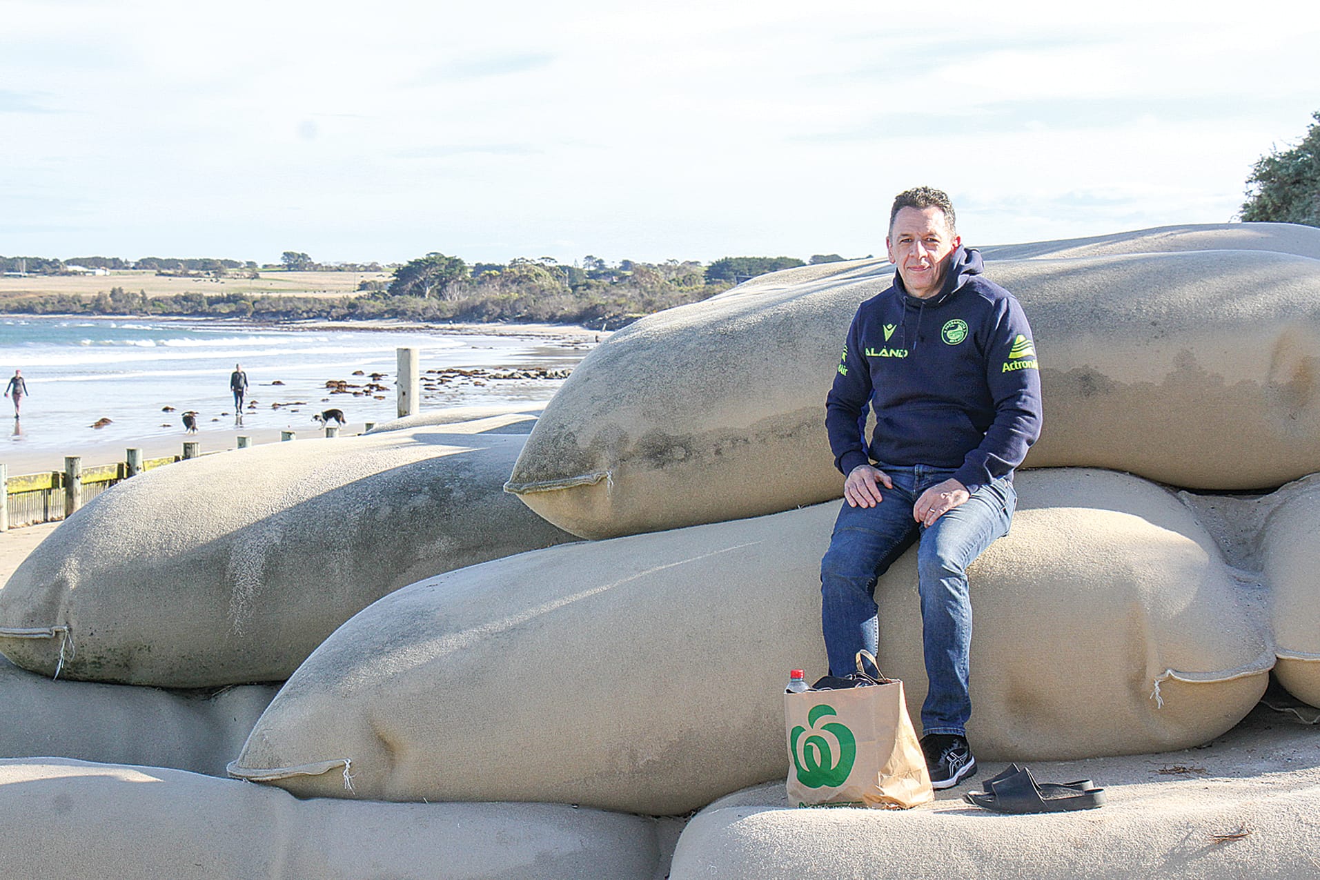 Dan Smith on geotextile sandbags at the Inverloch surf beach as coastal areas are put on alert for abnormally high tides and possible storm surges. B55_2125