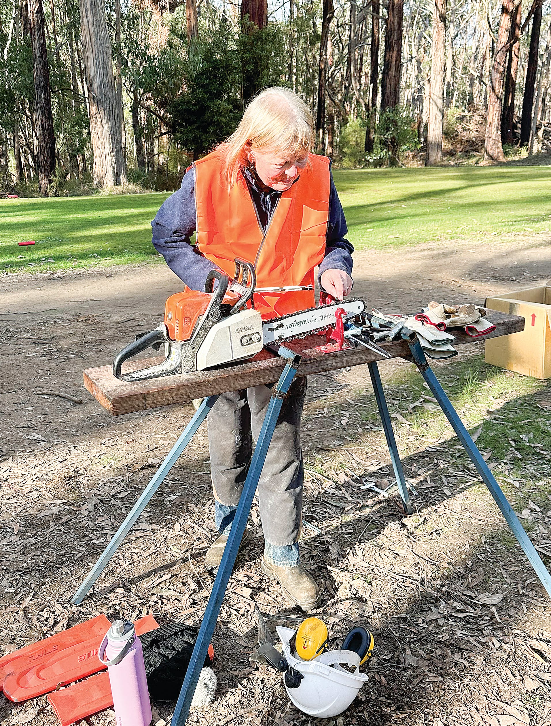 Participant Linda Ryan prepares her chainsaw for work.