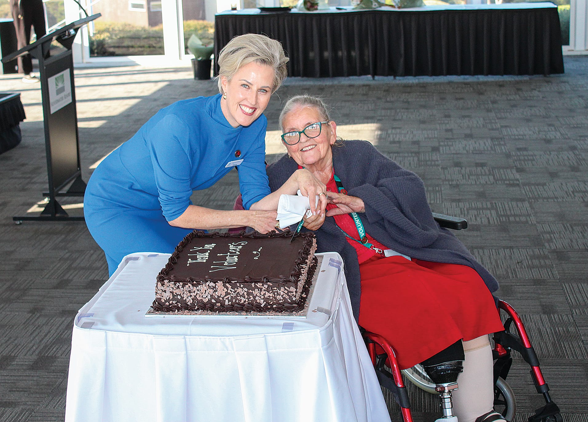 BCH Interim CEO Simone Alexander and Volunteer of 25 years, Candy Pile, cut a celebratory cake.