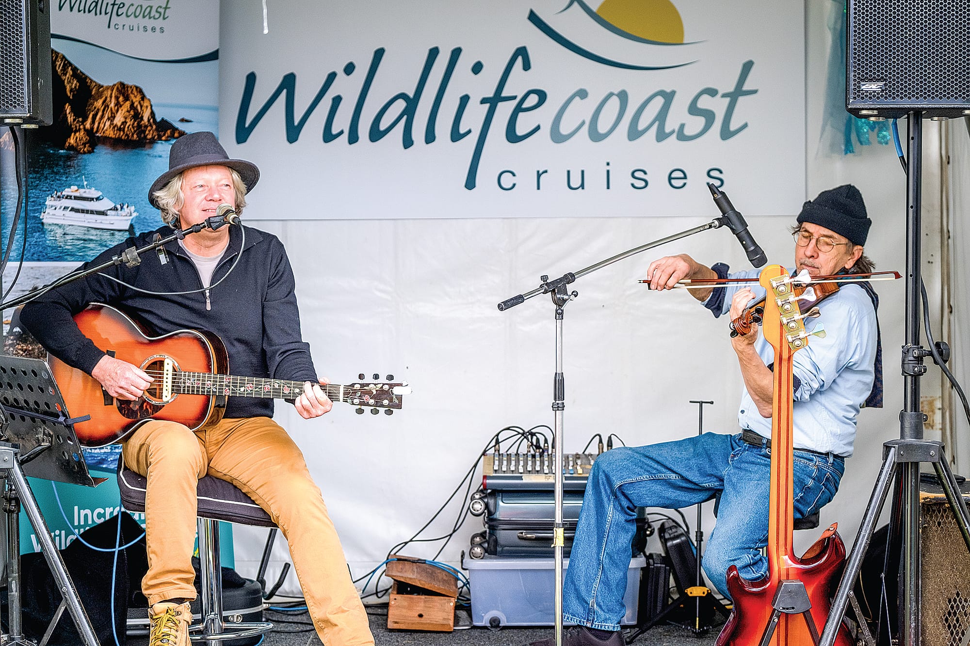 The Wildlife Coast Cruises music stage grooves with coastal rhythm as musicians keep the Festival Hub humming.